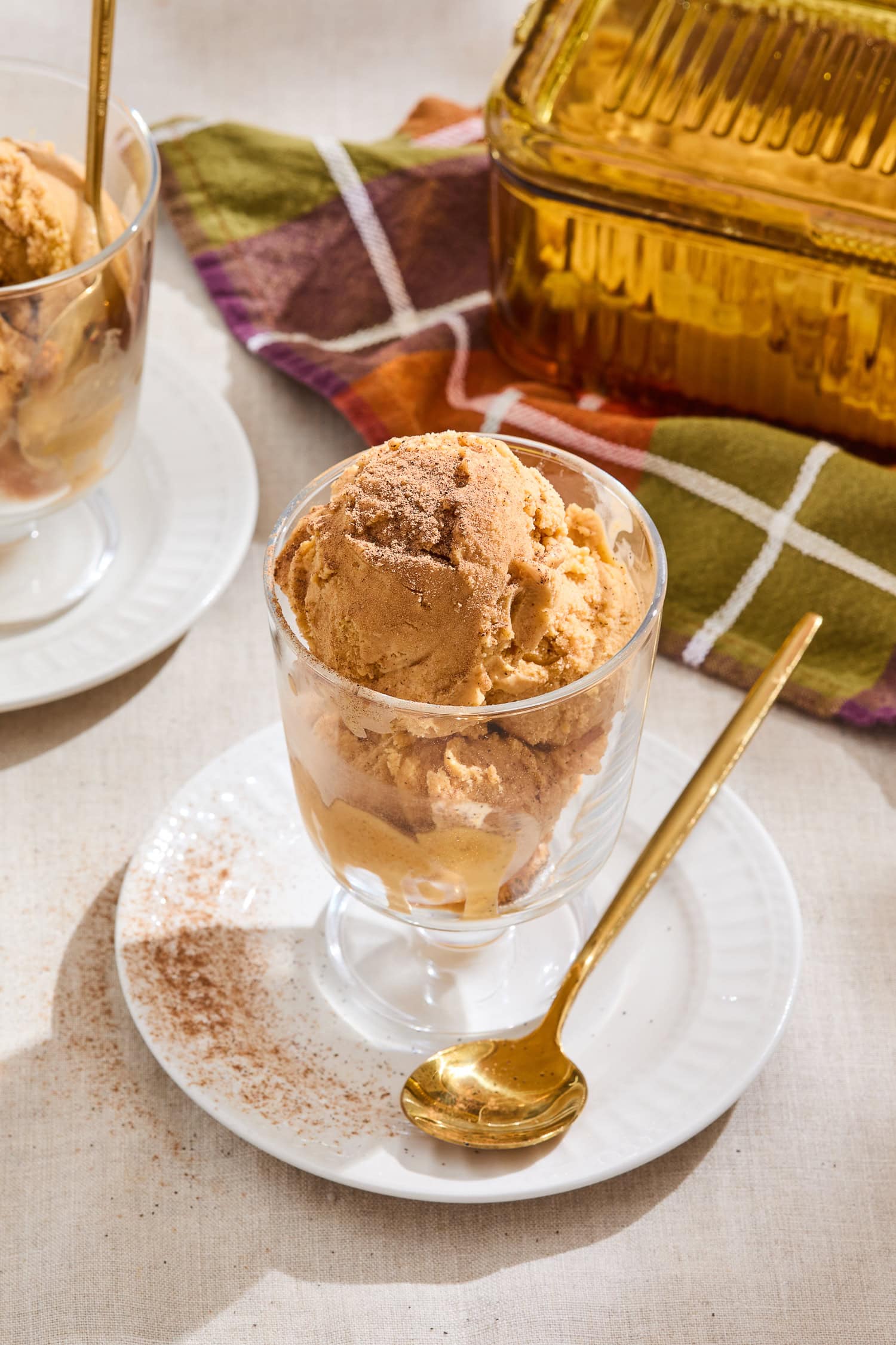 A glass serving dish with pumpkin ice cream.