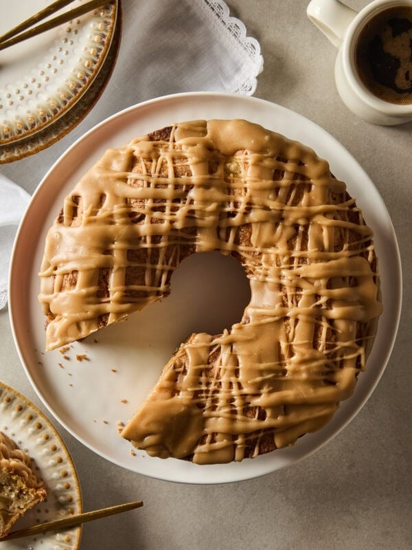 Spiced apple cake with a missing piece rests on a plate.