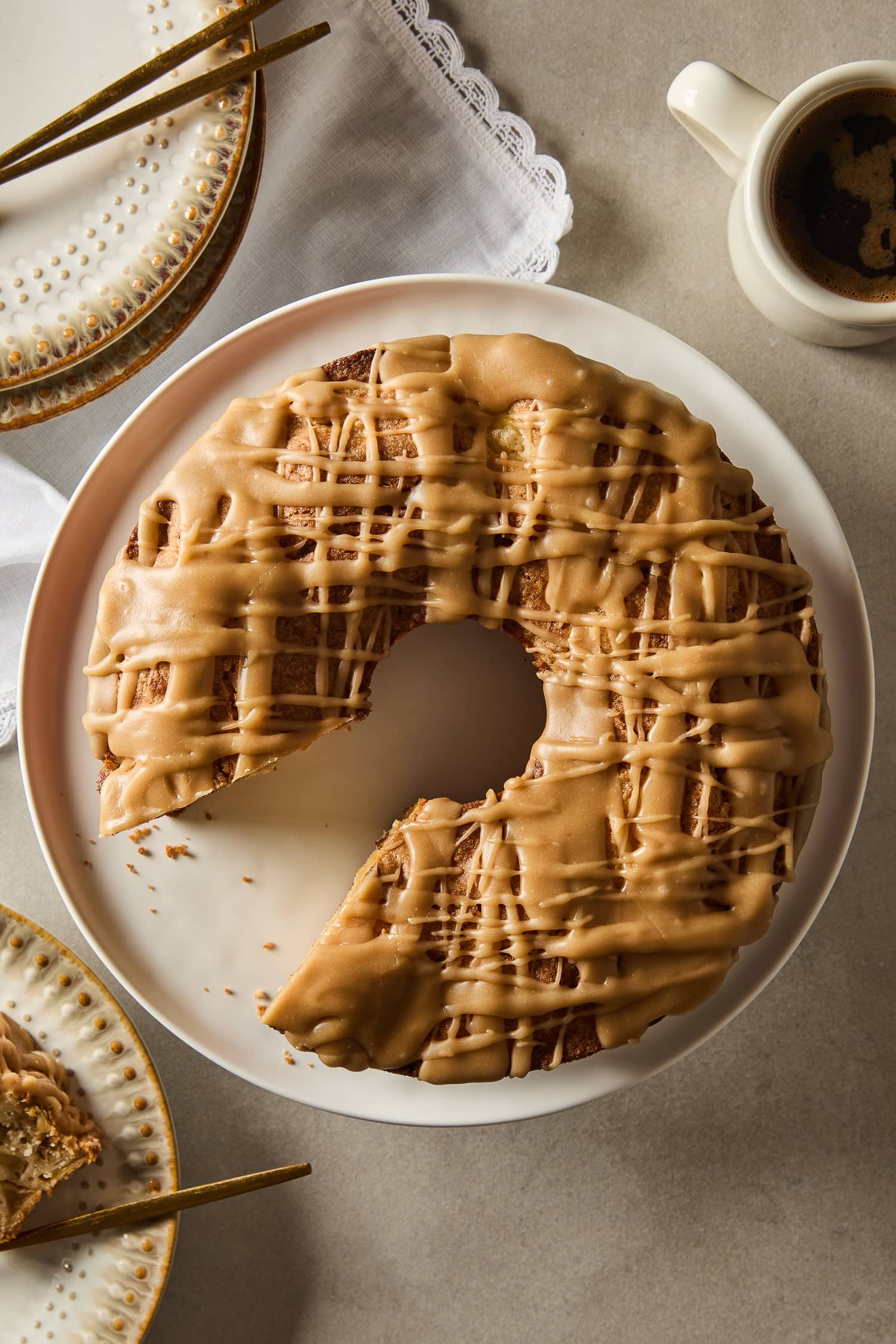 Apple cake with a missing piece rests on a plate.