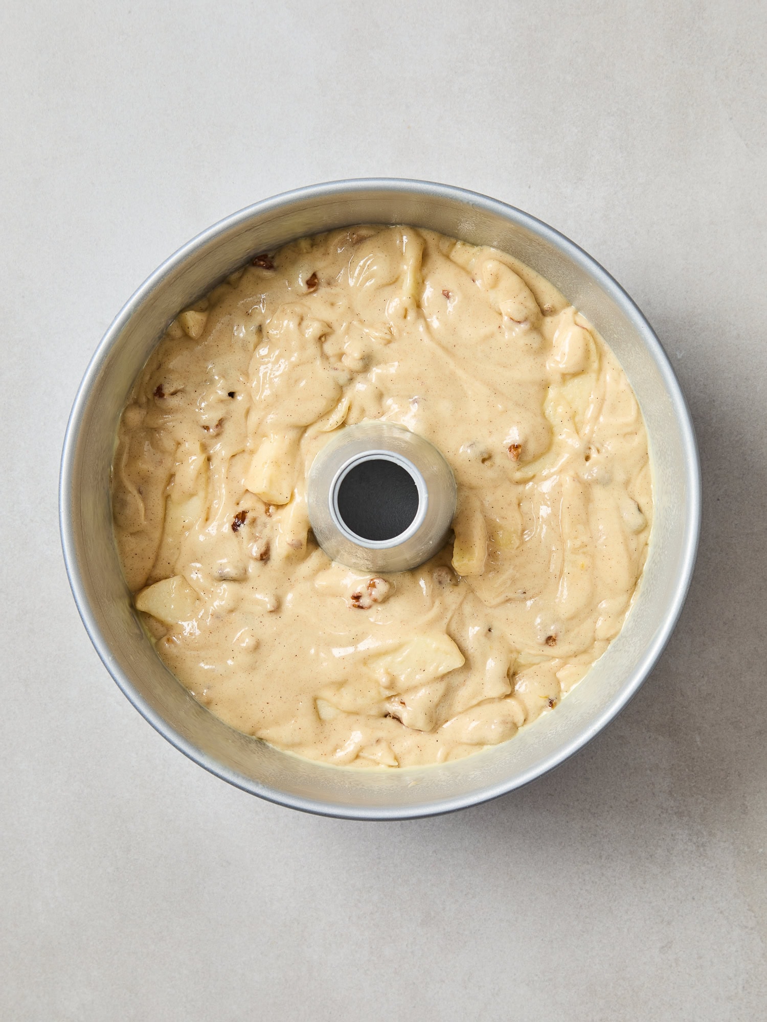 Spiced apple cake batter in a tube pan prior to baking.
