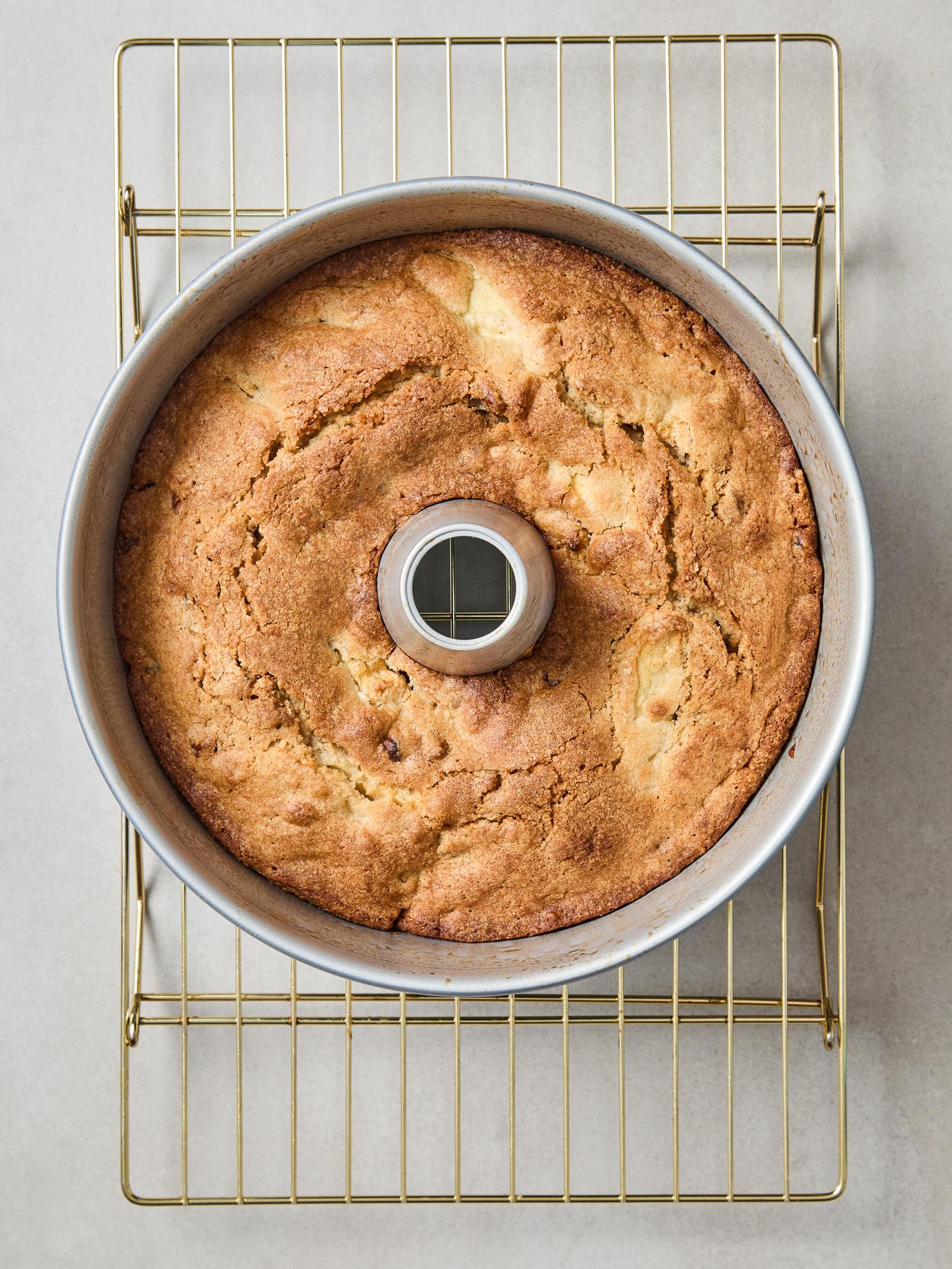 Cooling cake with in a tube pan resting on a cooling rack.