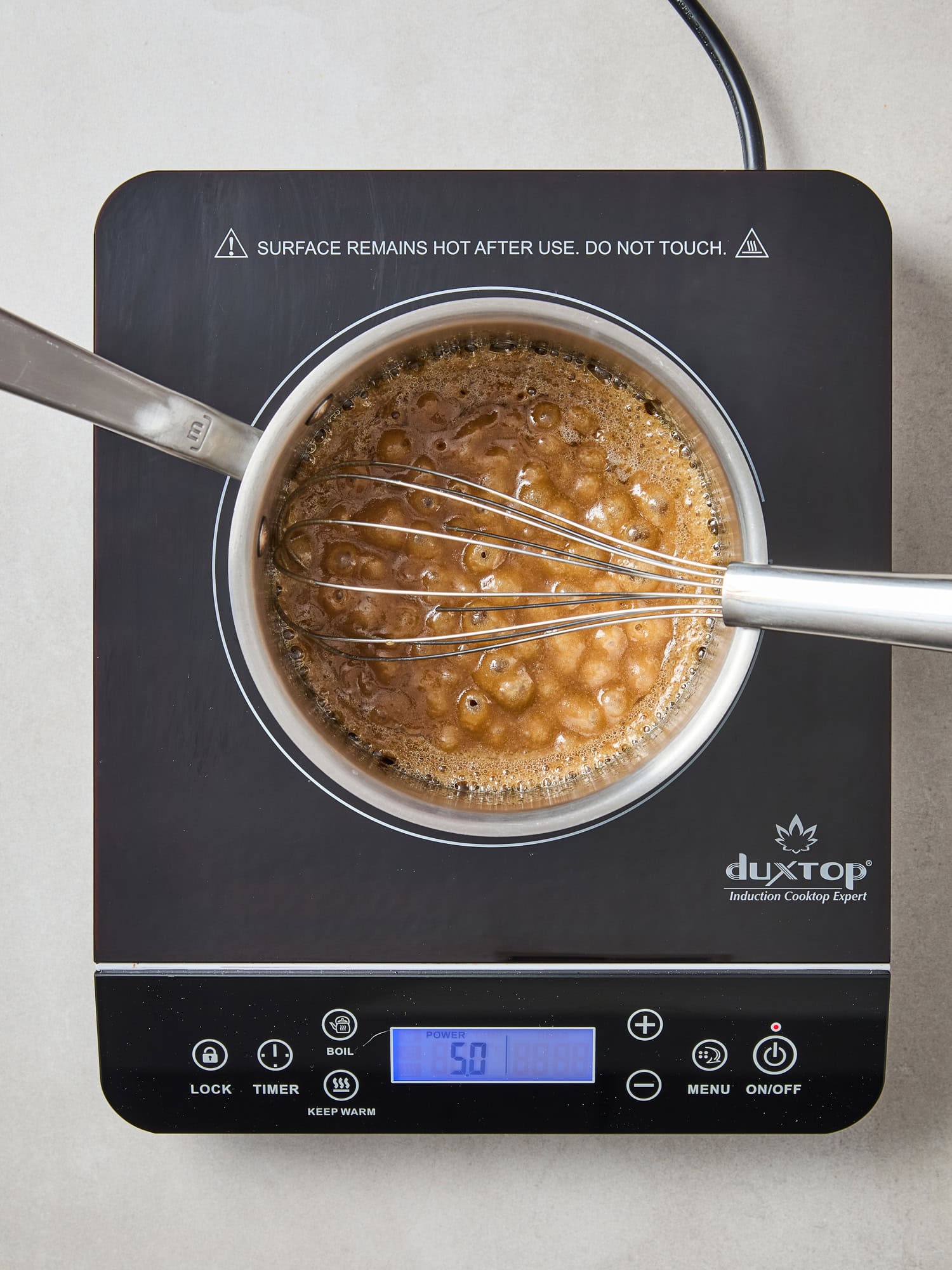 Cooking frosting for spiced apple cake.