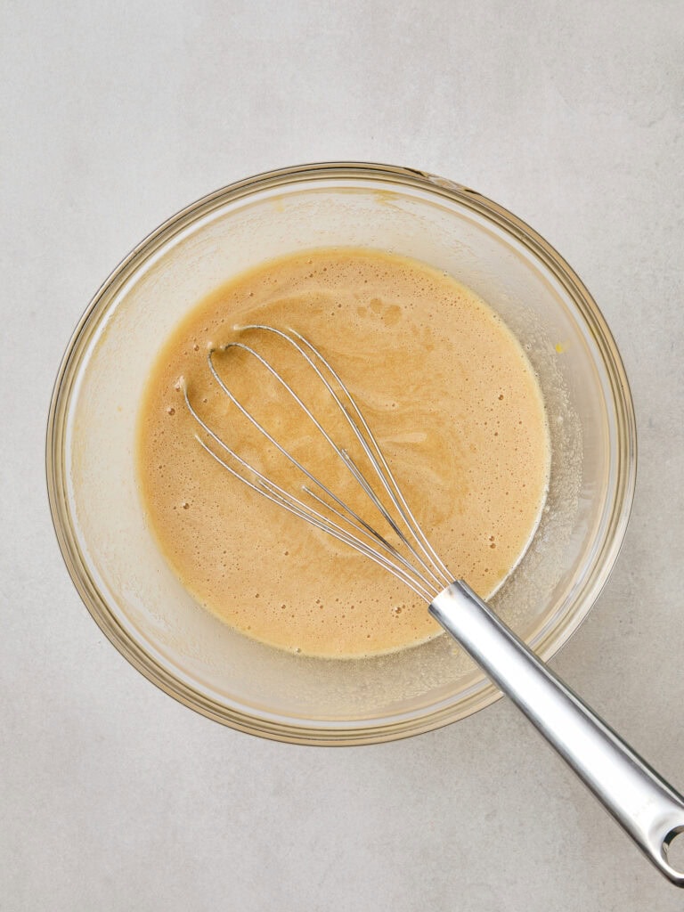 Wet ingredients for pumpkin spice donuts mixed together.