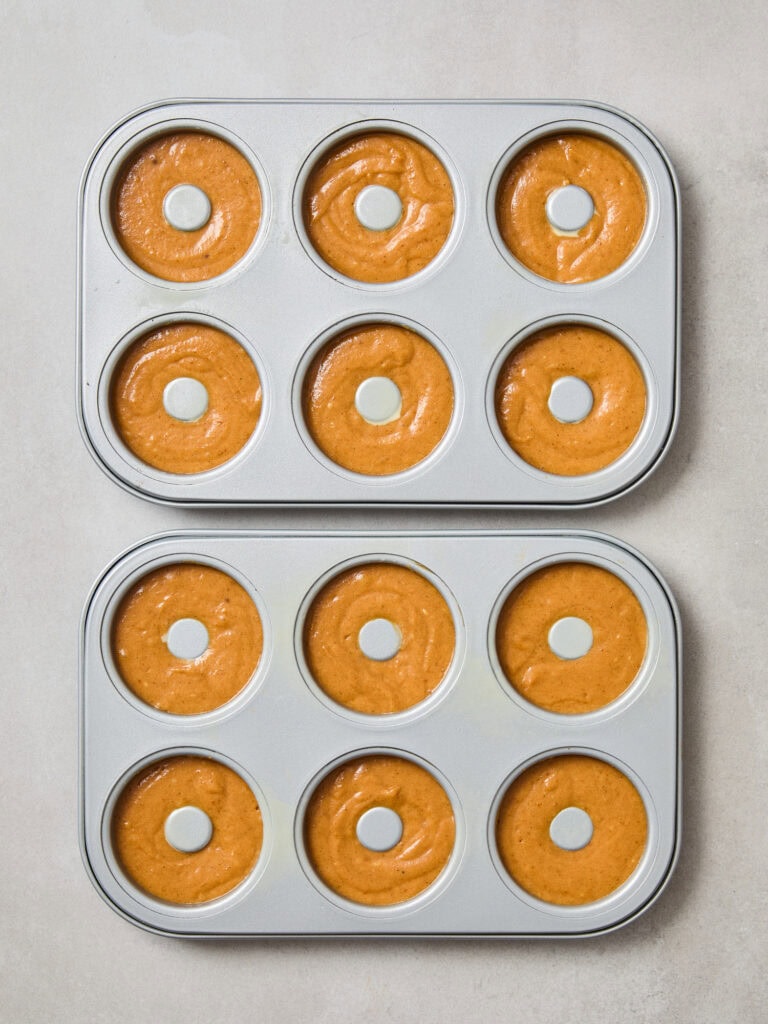 Pumpkin spice donut batter in donut pans prior to baking.