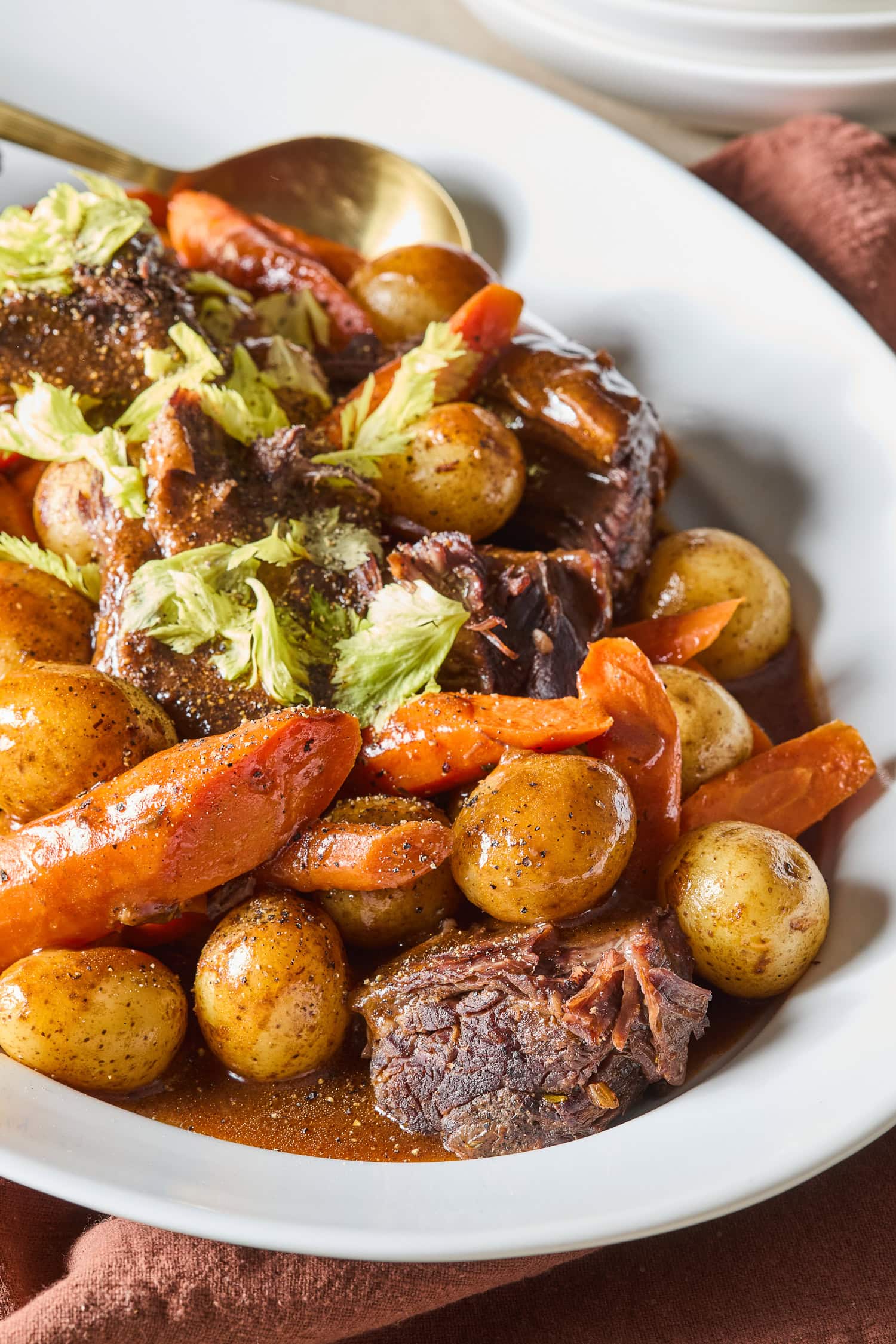 Roasted carrots and potatoes rest with cooked chuck roast on a platter.