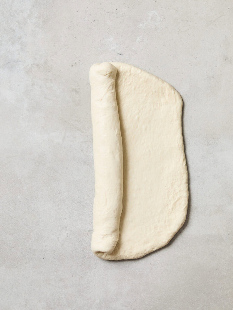 Bread dough being rolled into a form.