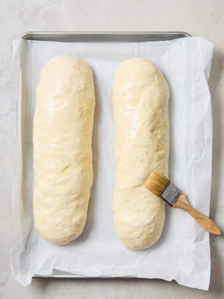 Brushing egg over bread dough prior to baking.