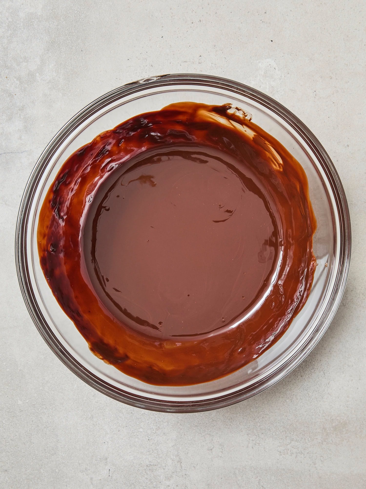 Glass bowl with melted chocolate and butter mixture.