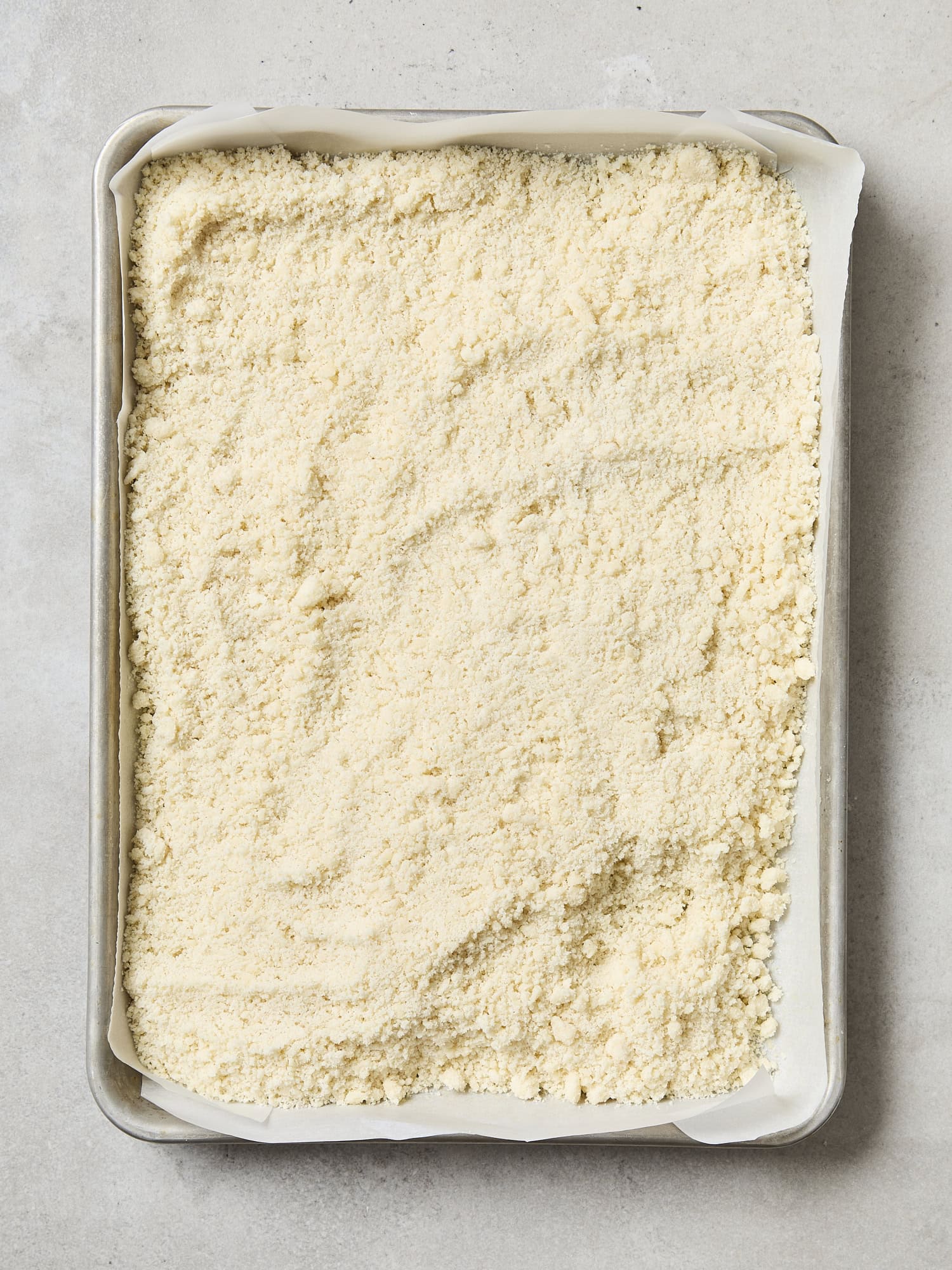 Unbaked shortbread layer for pecan pie bars in a baking dish.