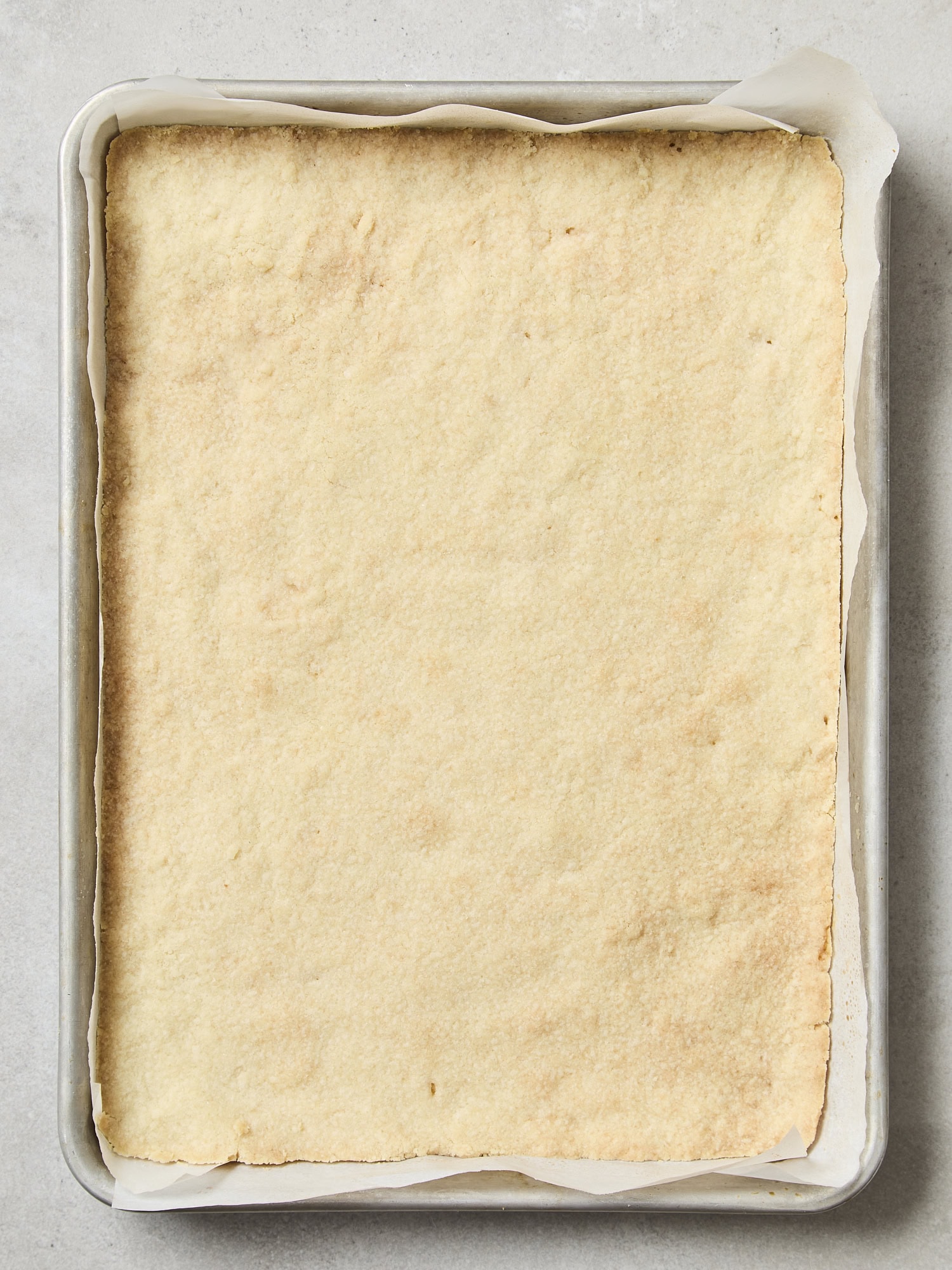 Baked shortbread layer of pecan pie bars.