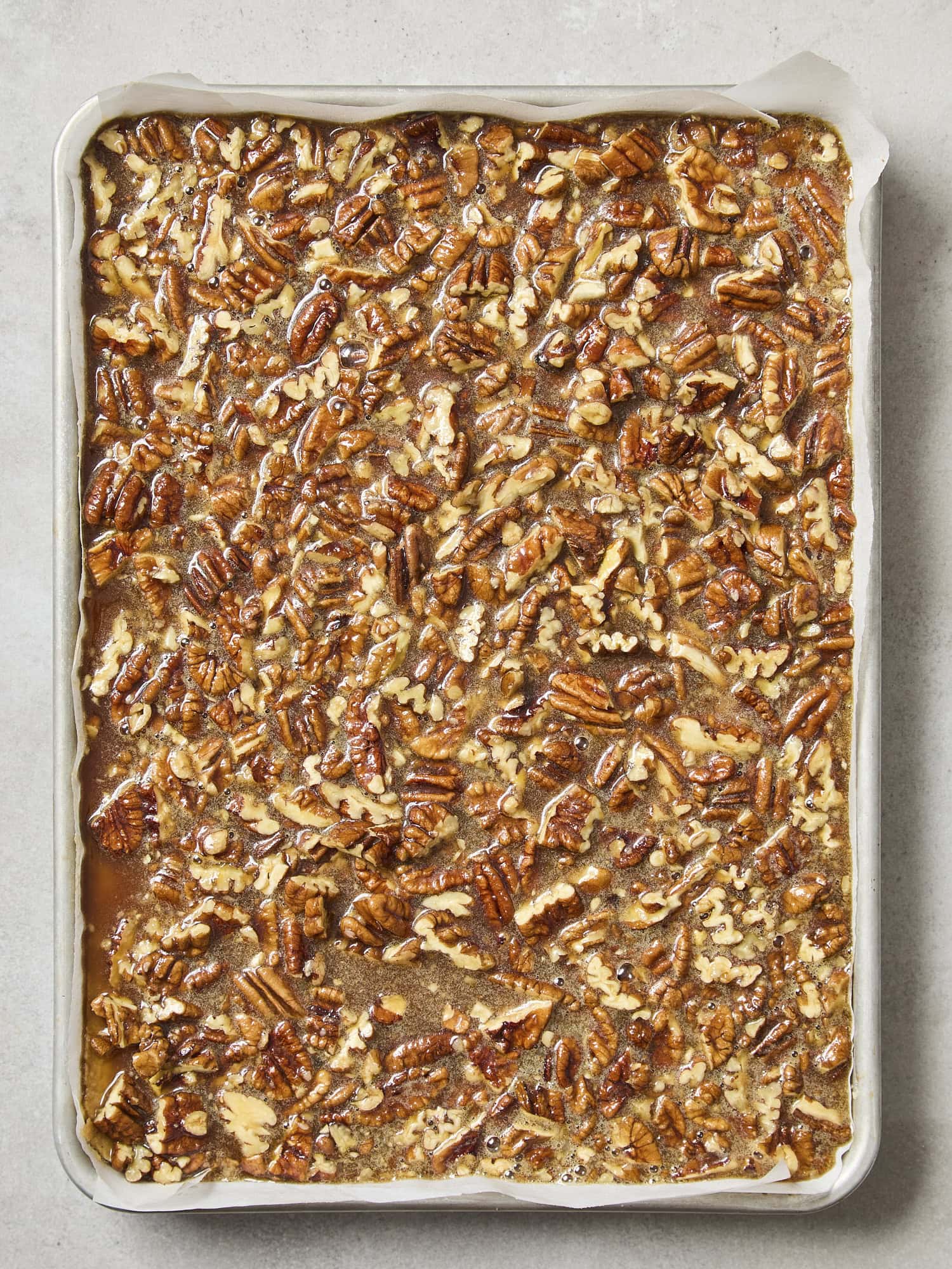 Unbaked pecan pie bars in a baking dish.