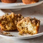 Pumpkin cheesecake muffin sliced in half showing interior texture.