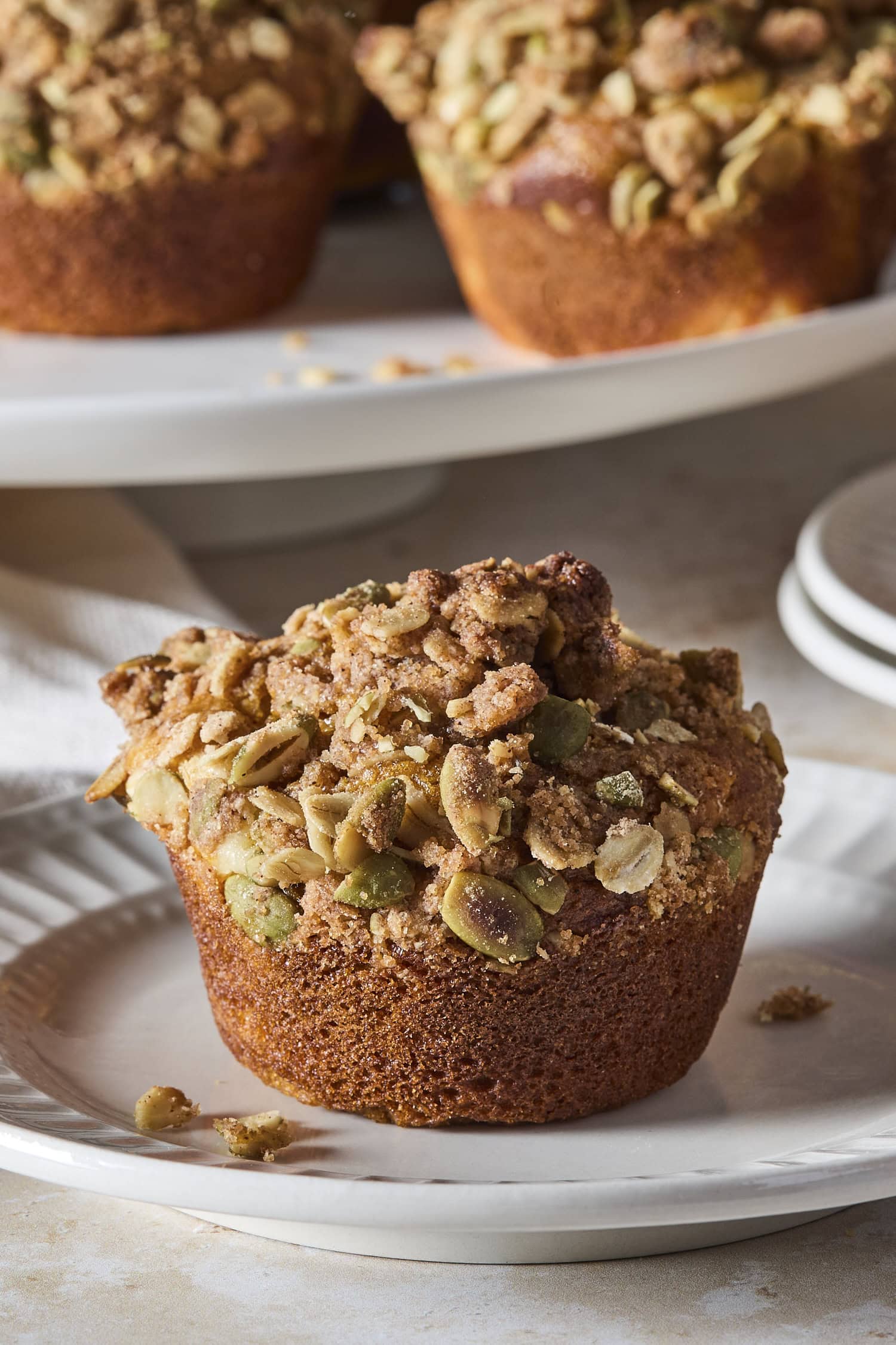 A pumpkin cheesecake muffin on a serving platter.
