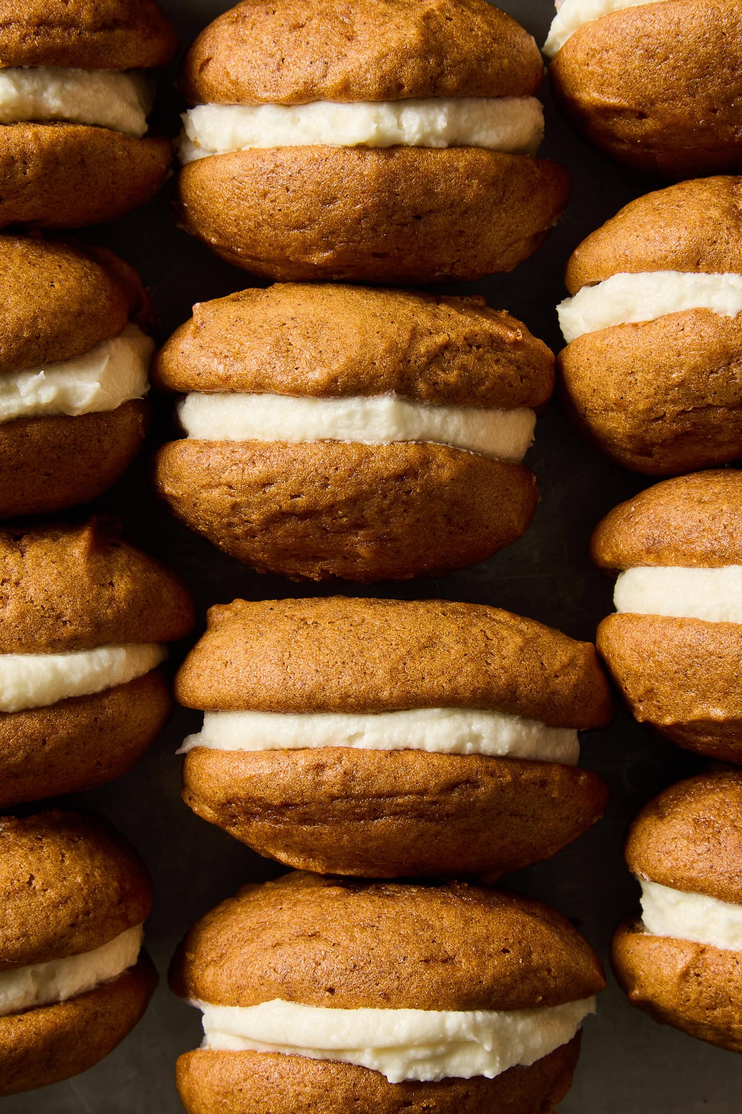 Pumpkin whoopie pies lined up next to each other.