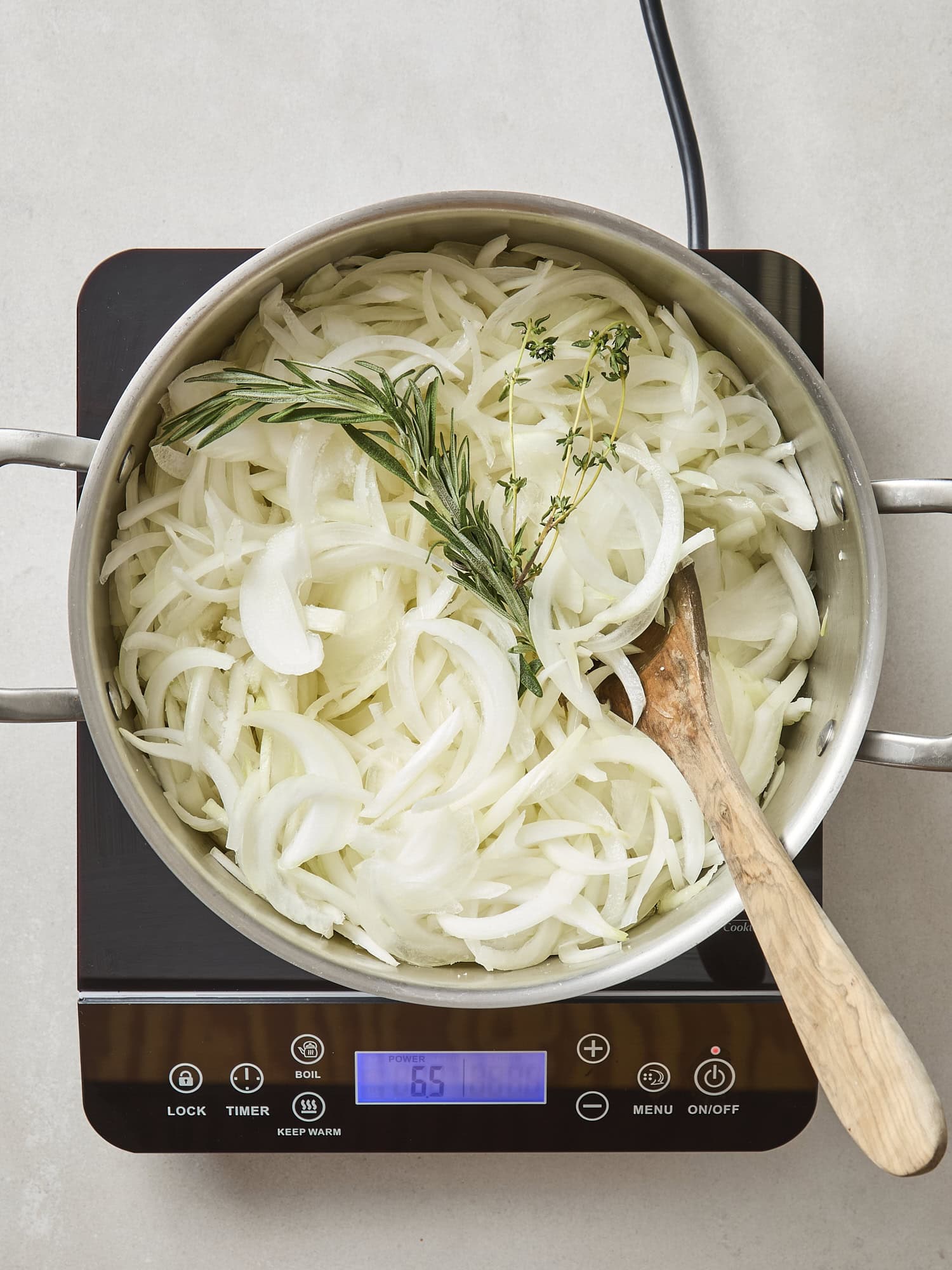 Raw sliced vegetables with herbs in a pot before cooking.