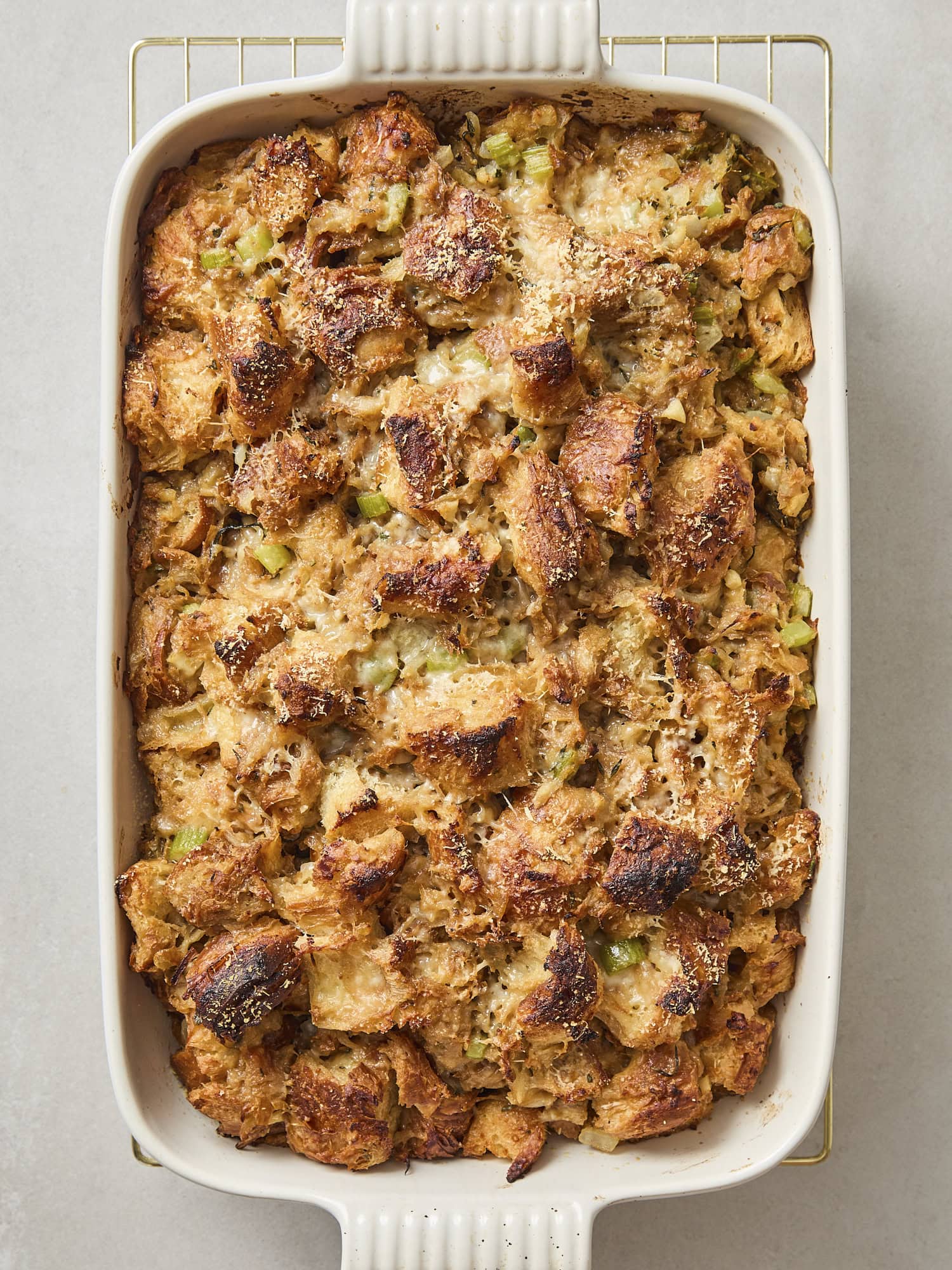 Baked stuffing in a white baking dish with crispy browned topping.