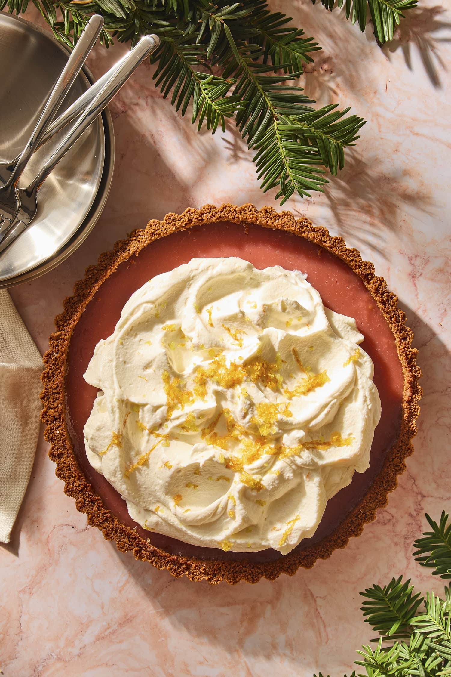 Cranberry tart with gingersnap cookie crust with orange whipped cream and sugared orange zest on top.