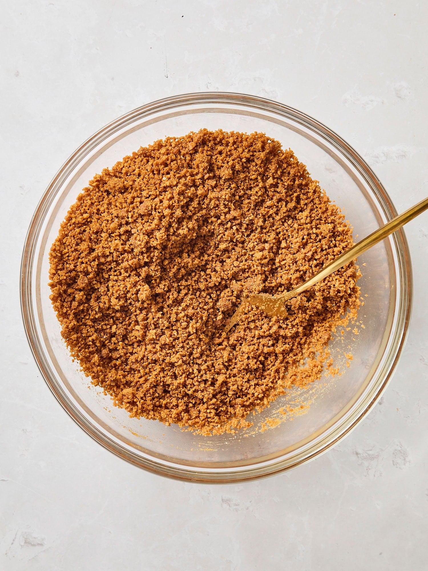 Gingersnap cookie crumbs in a glass bowl.