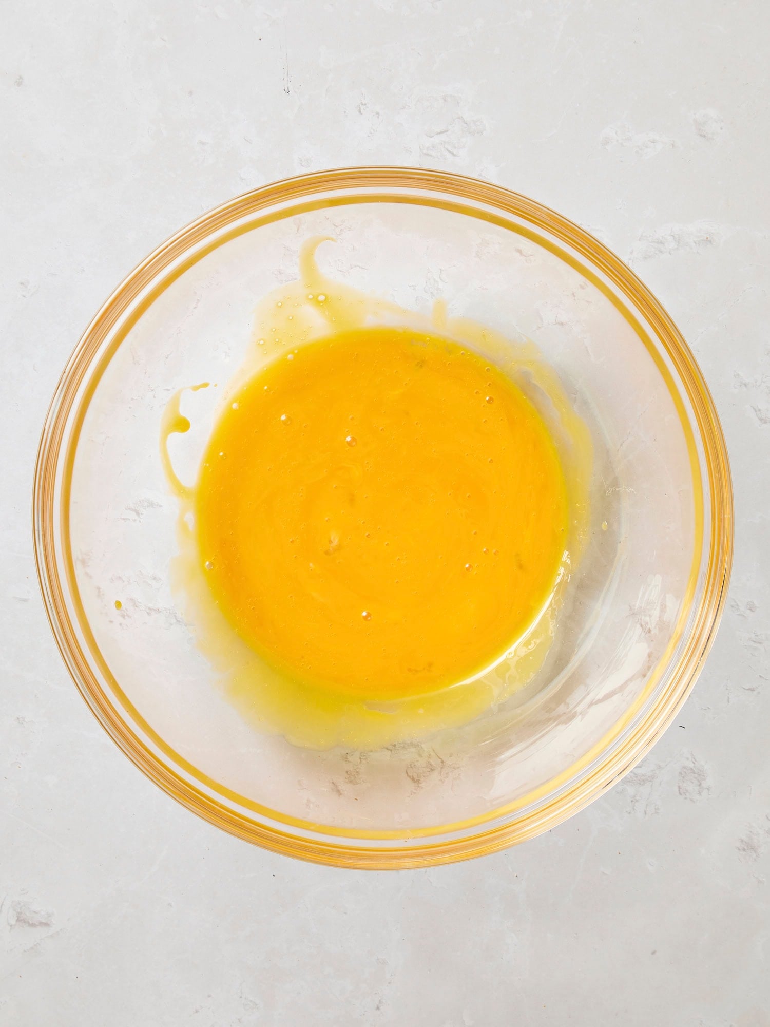 Glass bowl with whisked egg yolks.