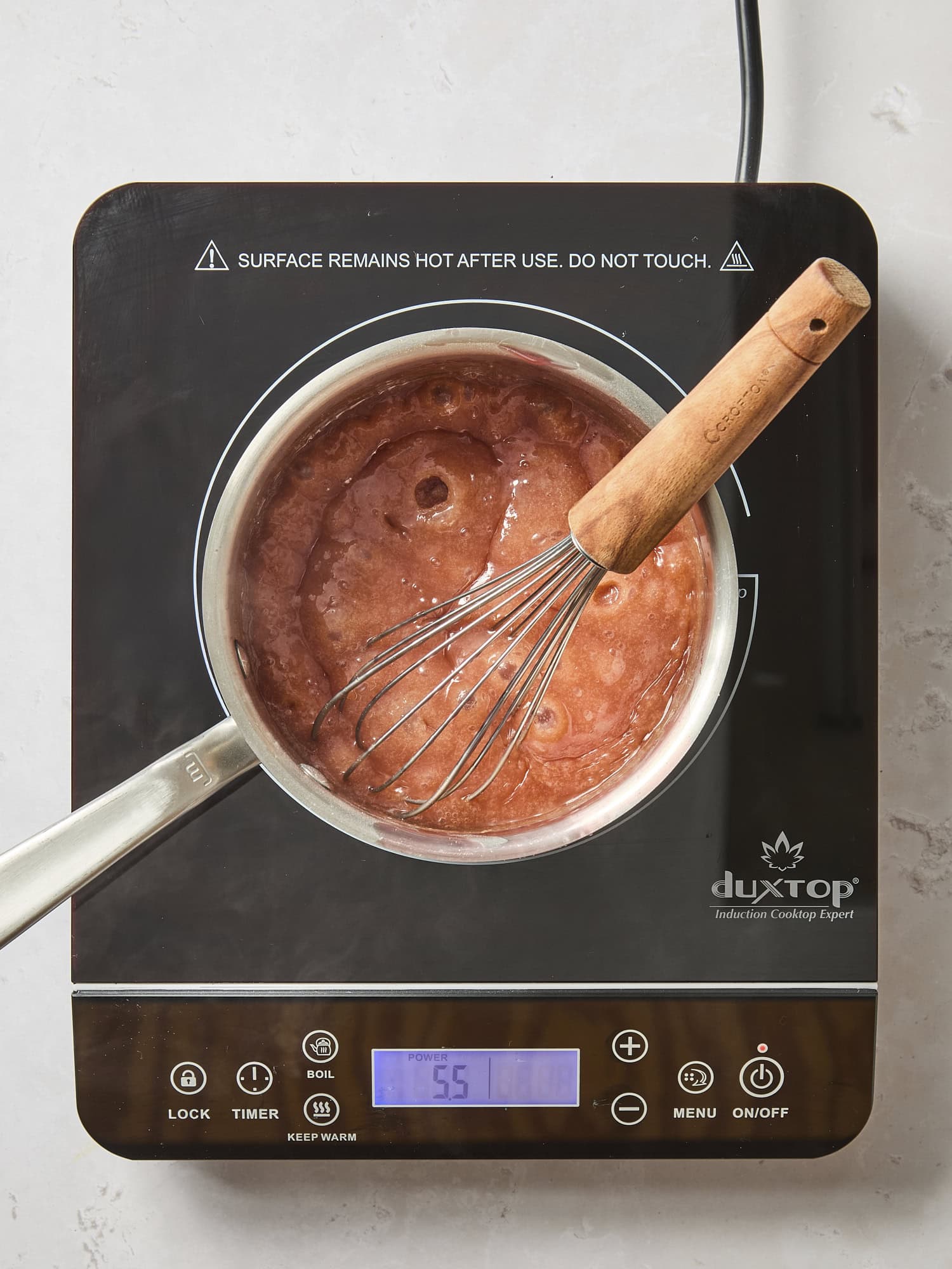 Cooking mixture of cranberry filling on cooktop.