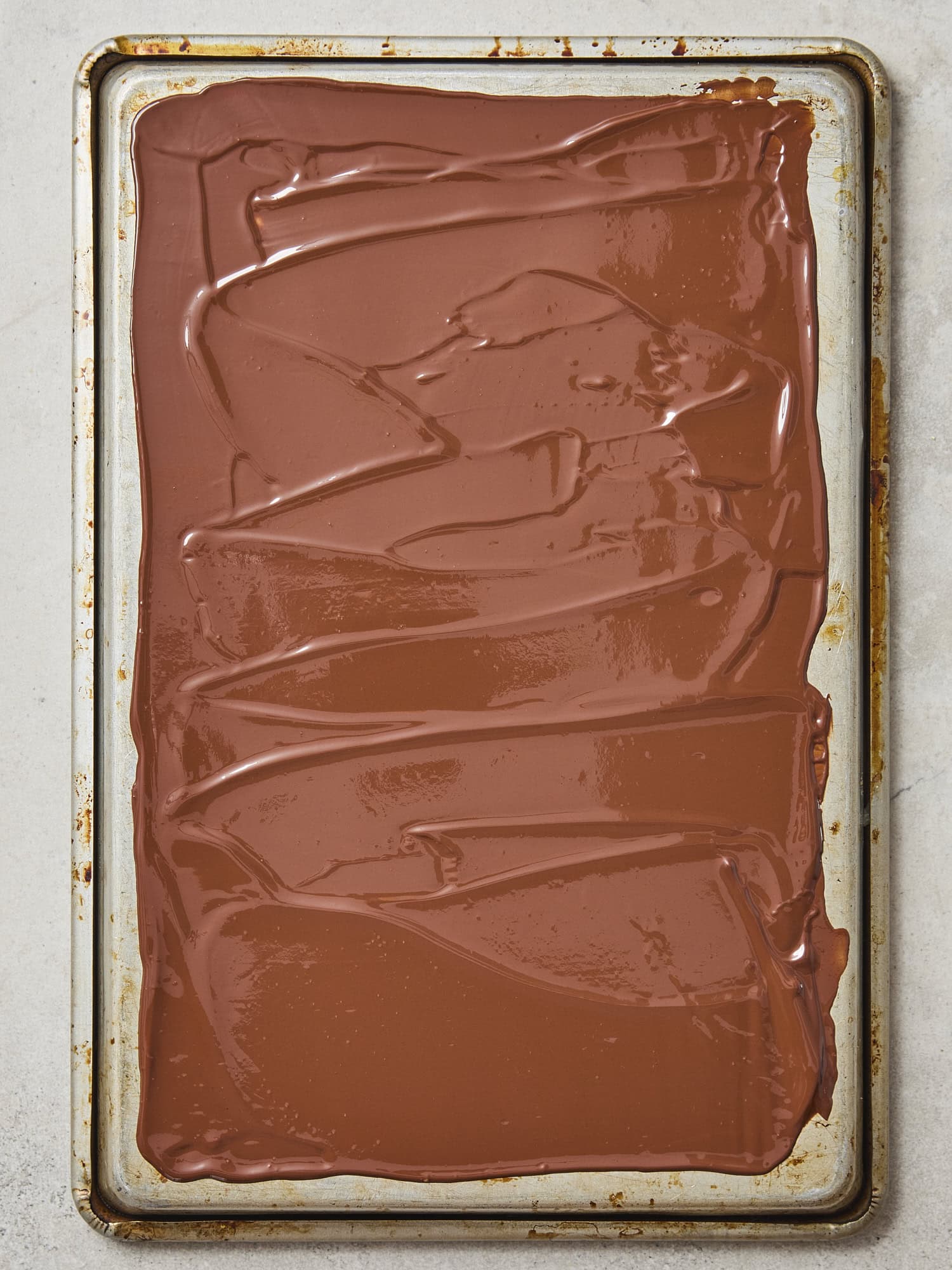 Melted chocolate before cooling on the back of a baking sheet.