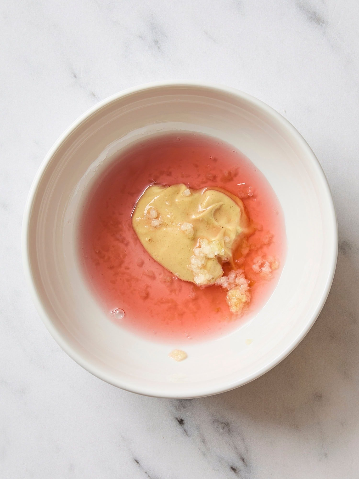 Components for a vinaigrette in a white bowl.