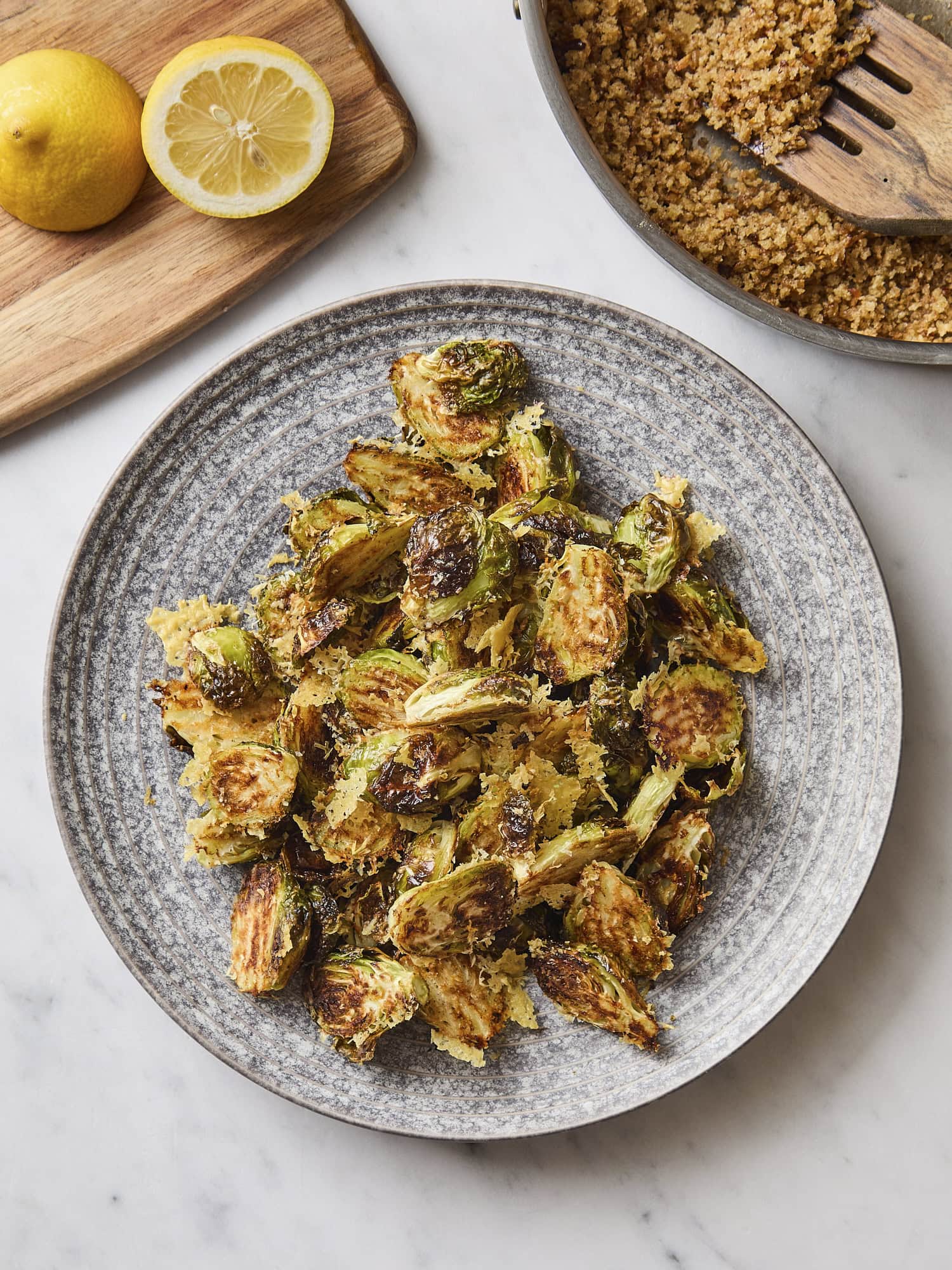 Platter with roasted Brussels sprouts with breadcrumb mixture to the side.