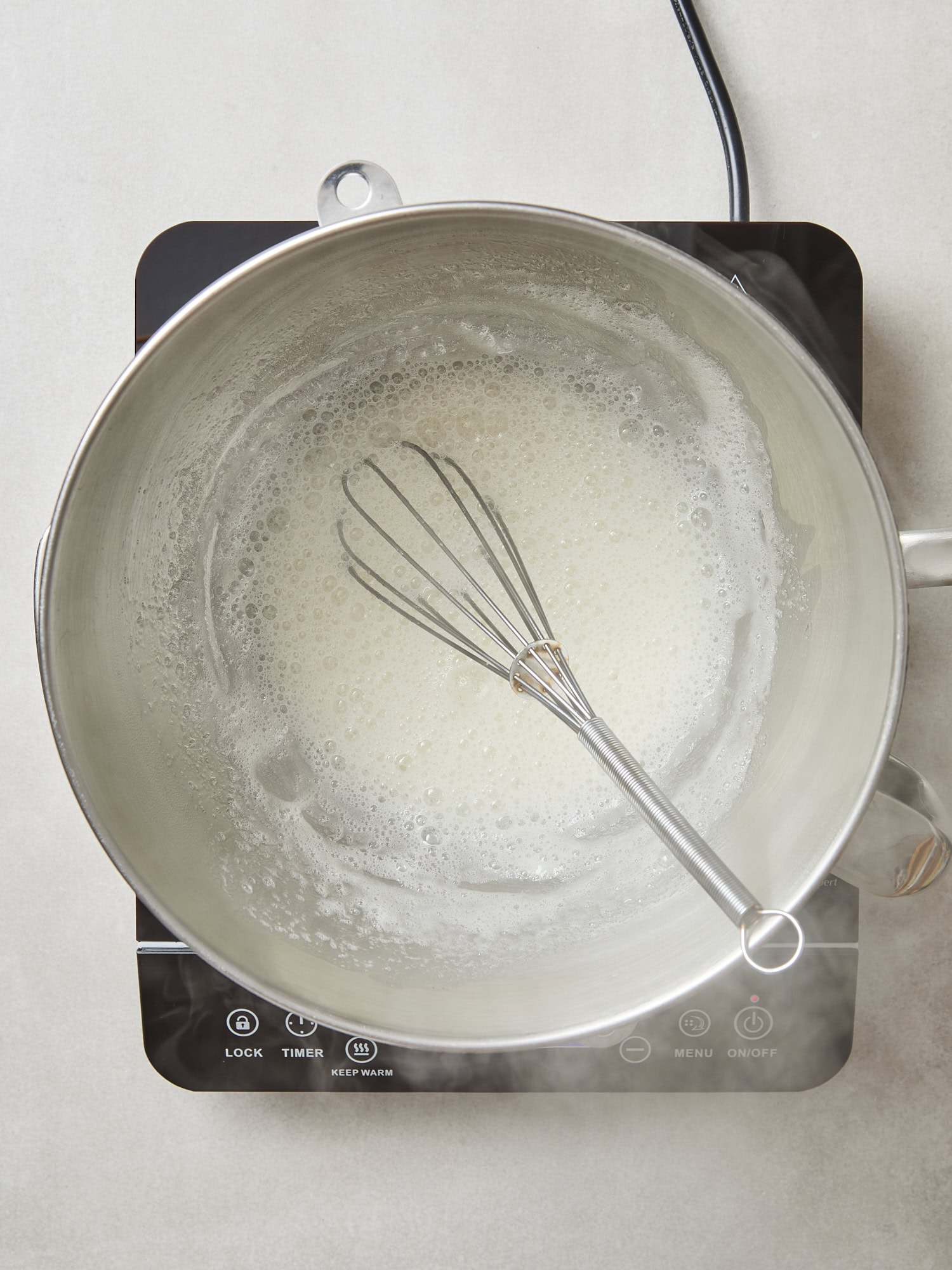 Heated meringue topping in a mixing bowl.