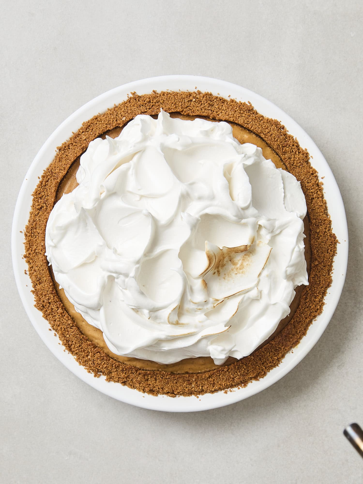 Pumpkin pie with meringue topping beginning to be brûléed.