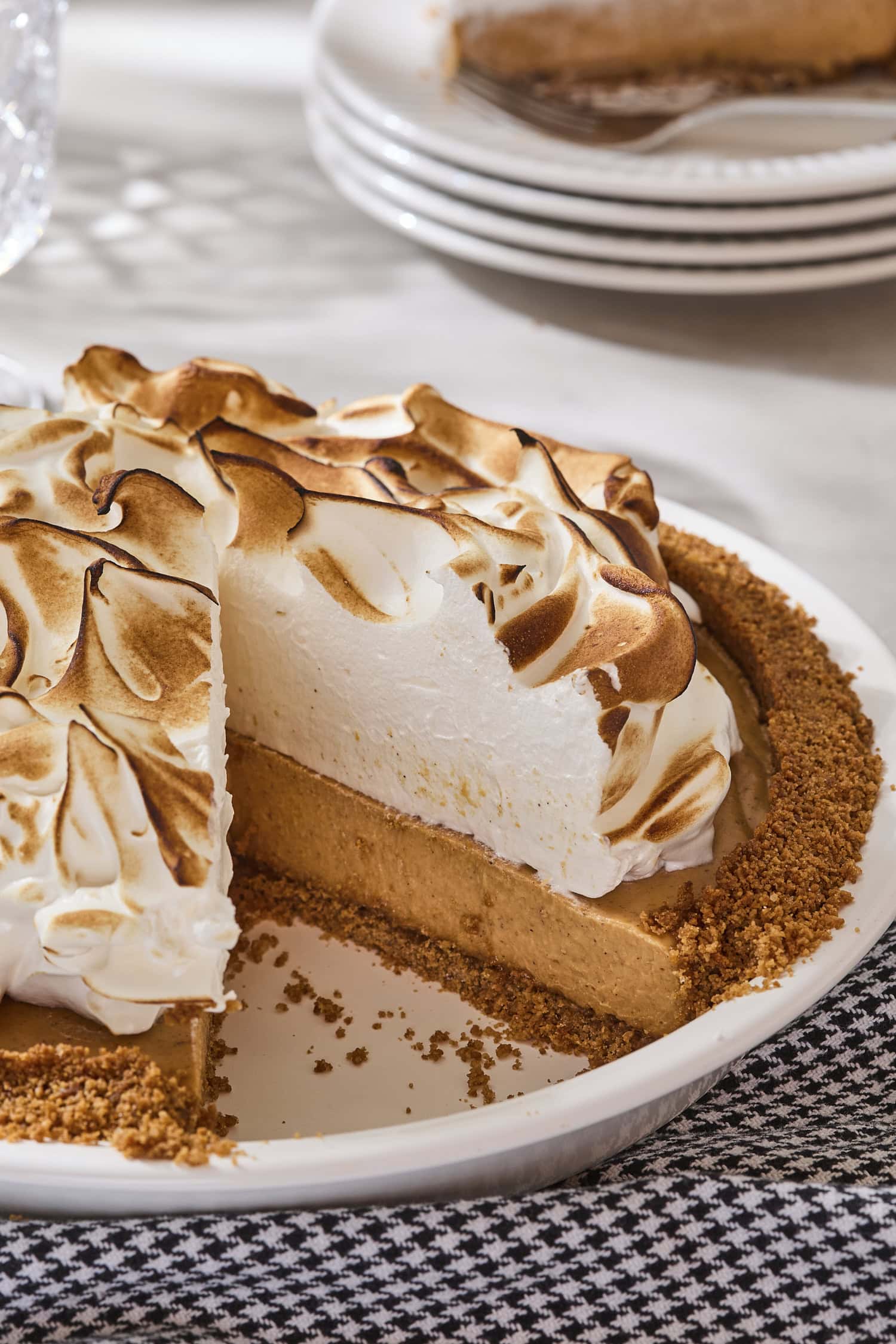 Pumpkin pie with meringue topping with a slice removed.