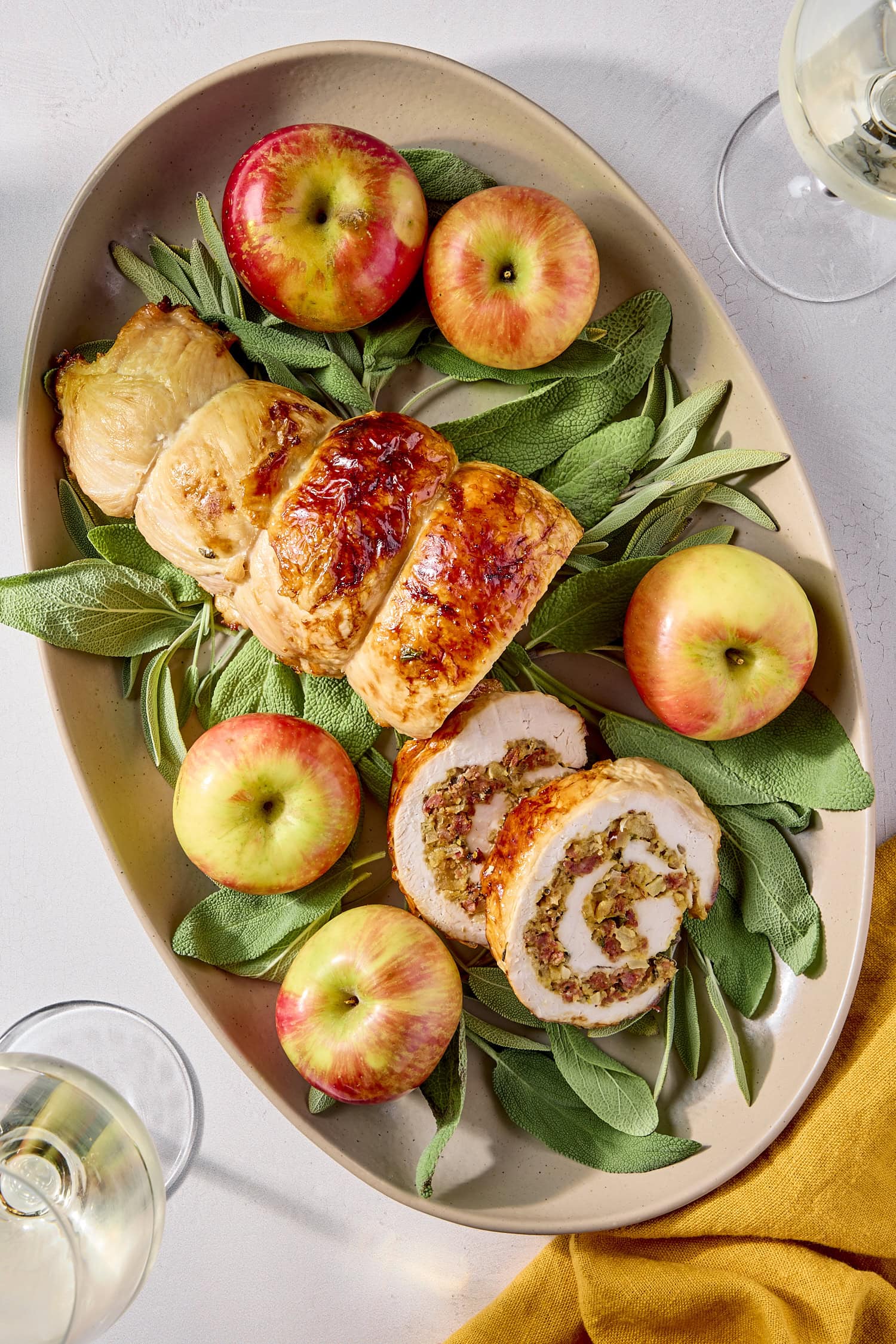 Serving platter with turkey roulade with swirls made of sausage, sage, and apple filling.