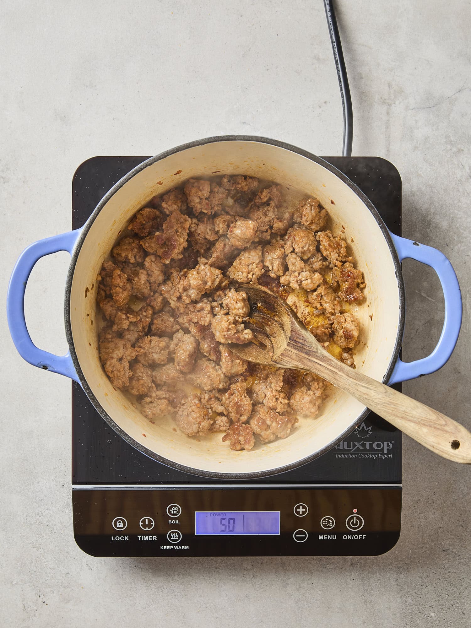 Pot with cooked browned sausage.