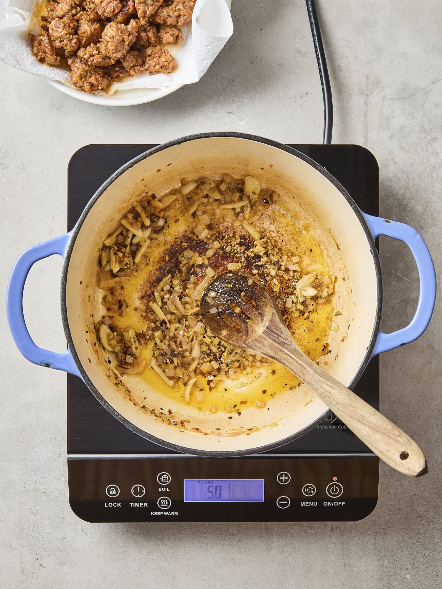 Dutch oven on a cookbook with sautéed onions and spices.