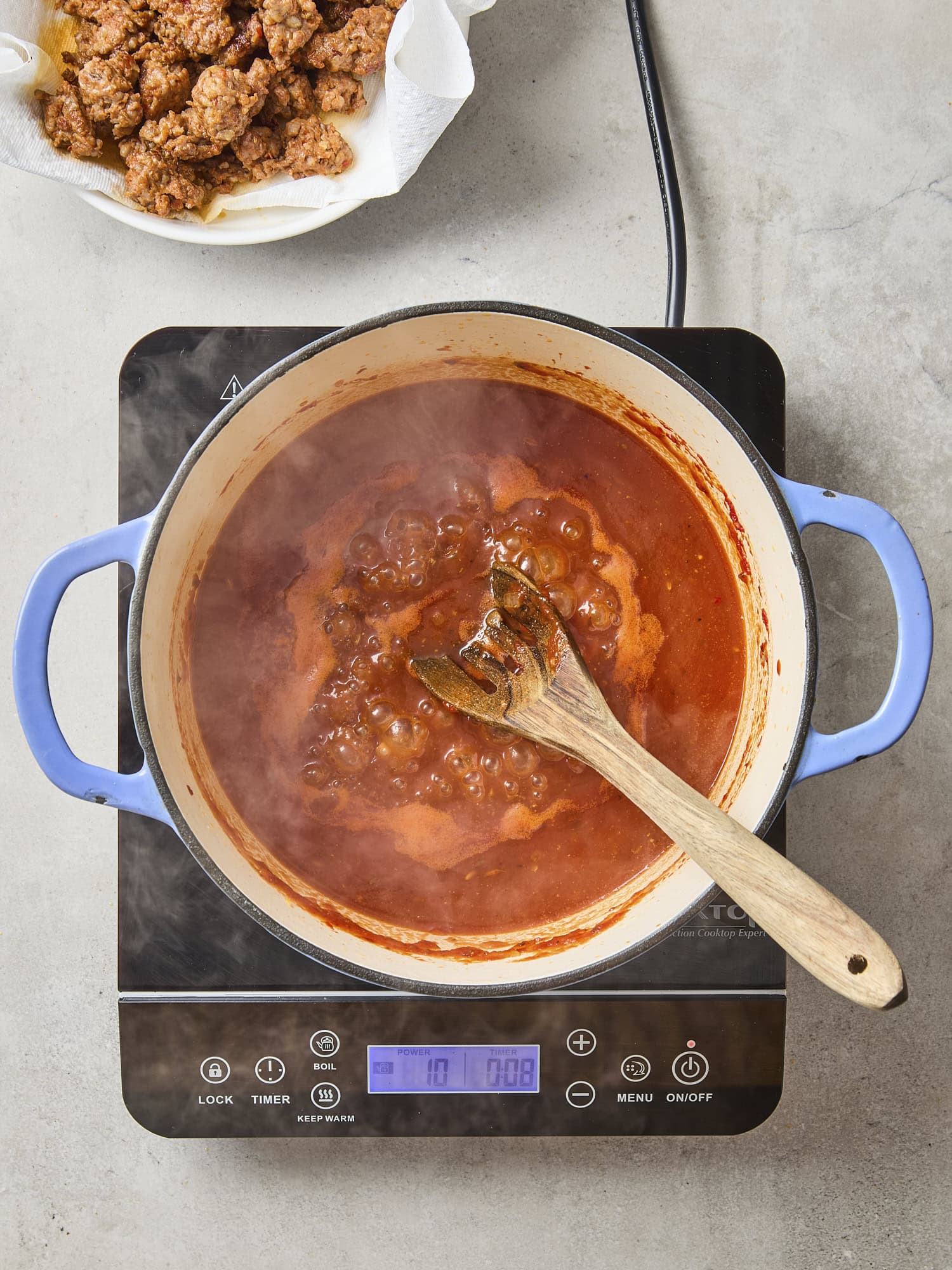 Pot with bubbling red tomato-based sauce.