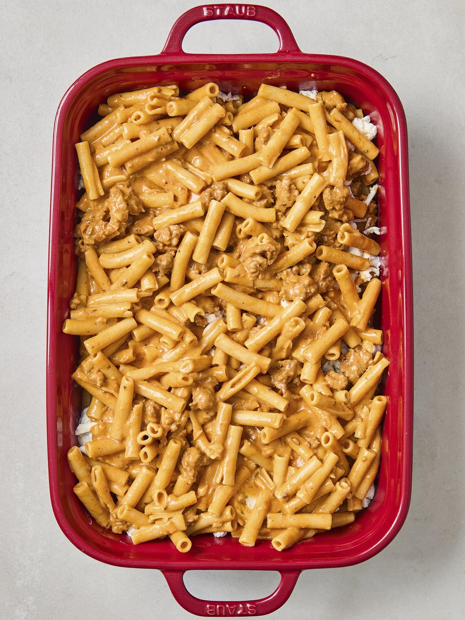 Red baking pan with pasta for baked ziti.