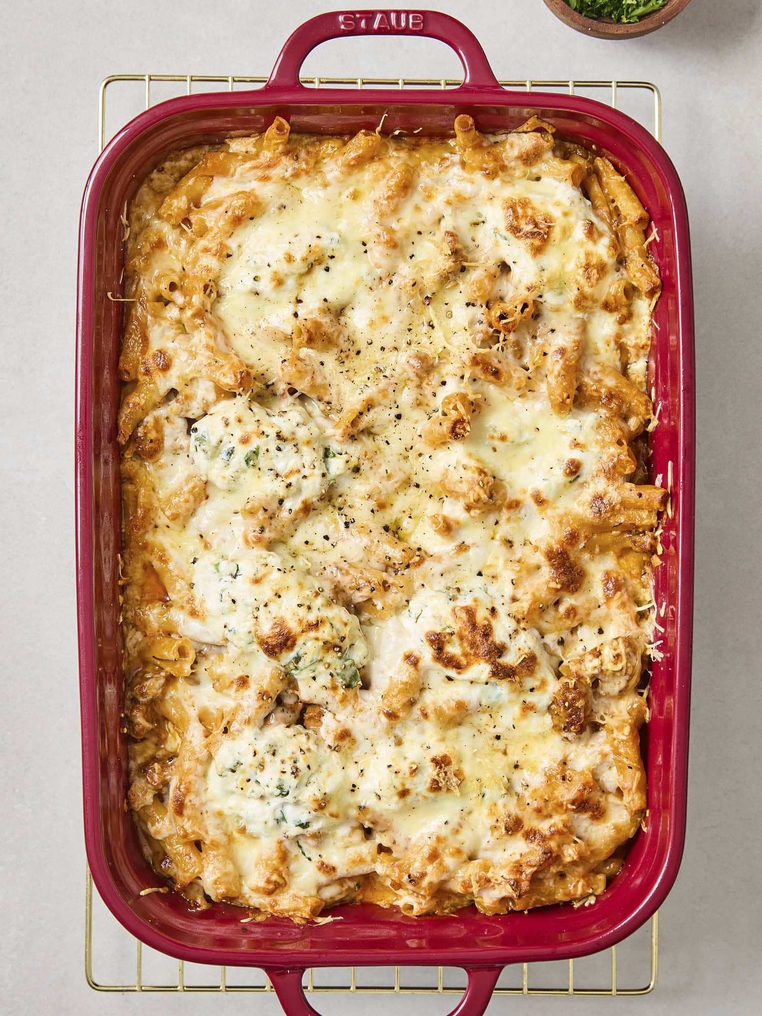 Red baking pan with baked ziti.
