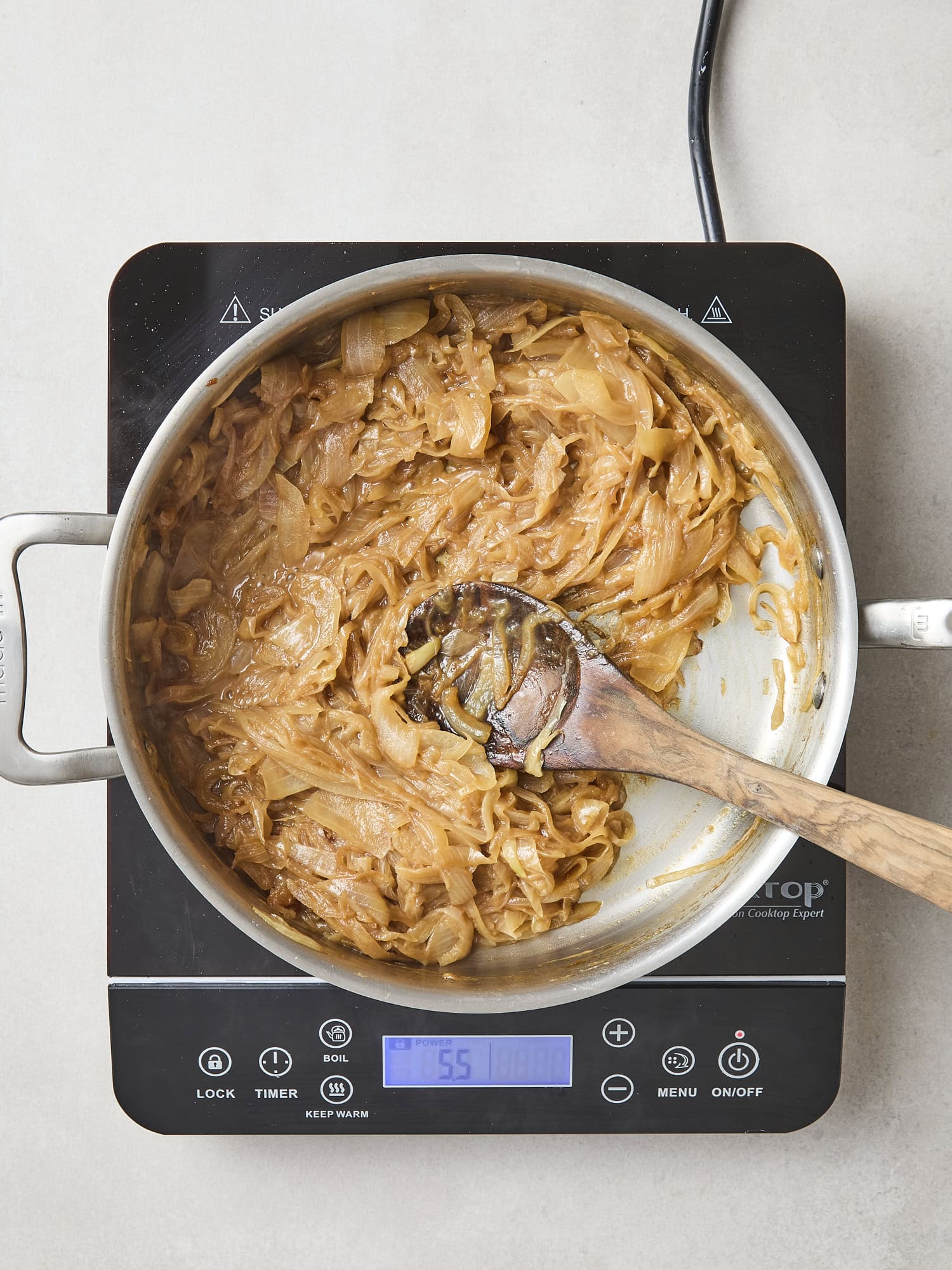 Pan set over heat with caramelized onions cooking and browning.