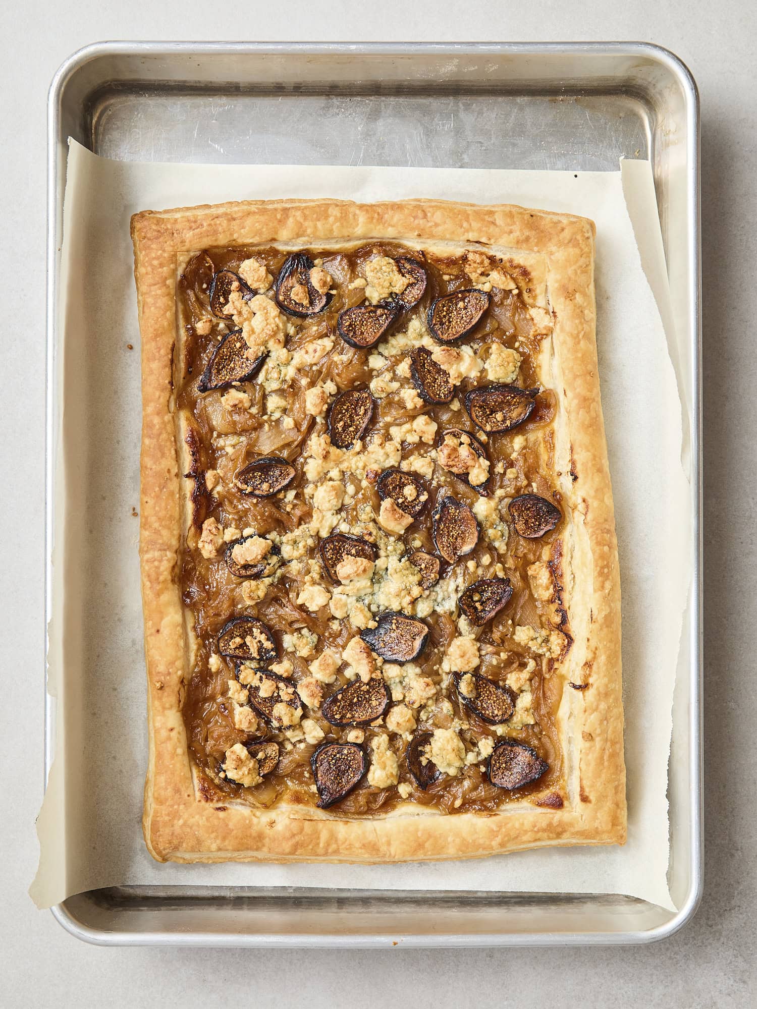 Baked caramelized onion tart with browned top with figs and blue cheese.