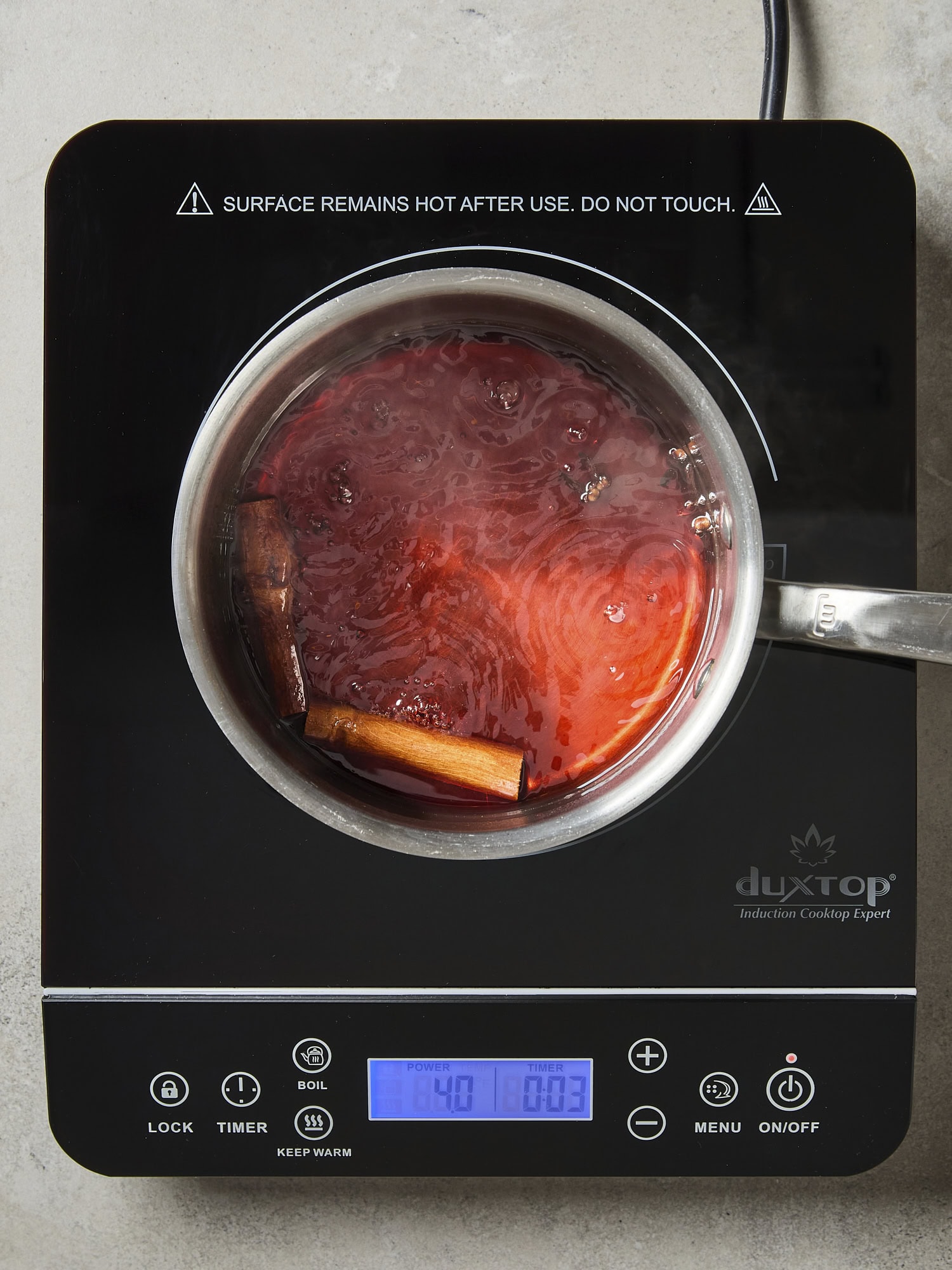 Cranberry simple syrup mixture cooking on the stove in a pan.