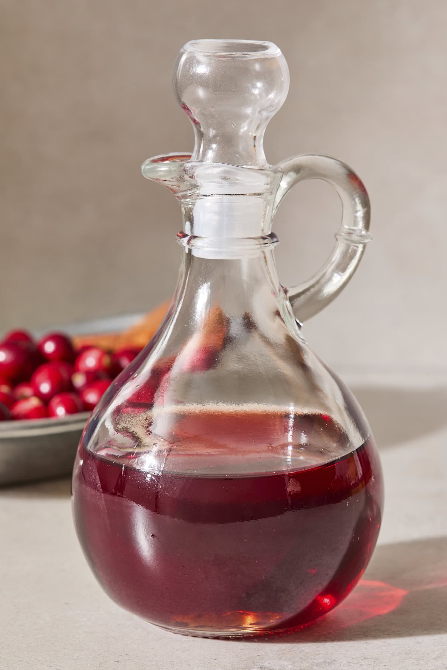 Glass container filled with red-colored simple syrup with the stopper on top.