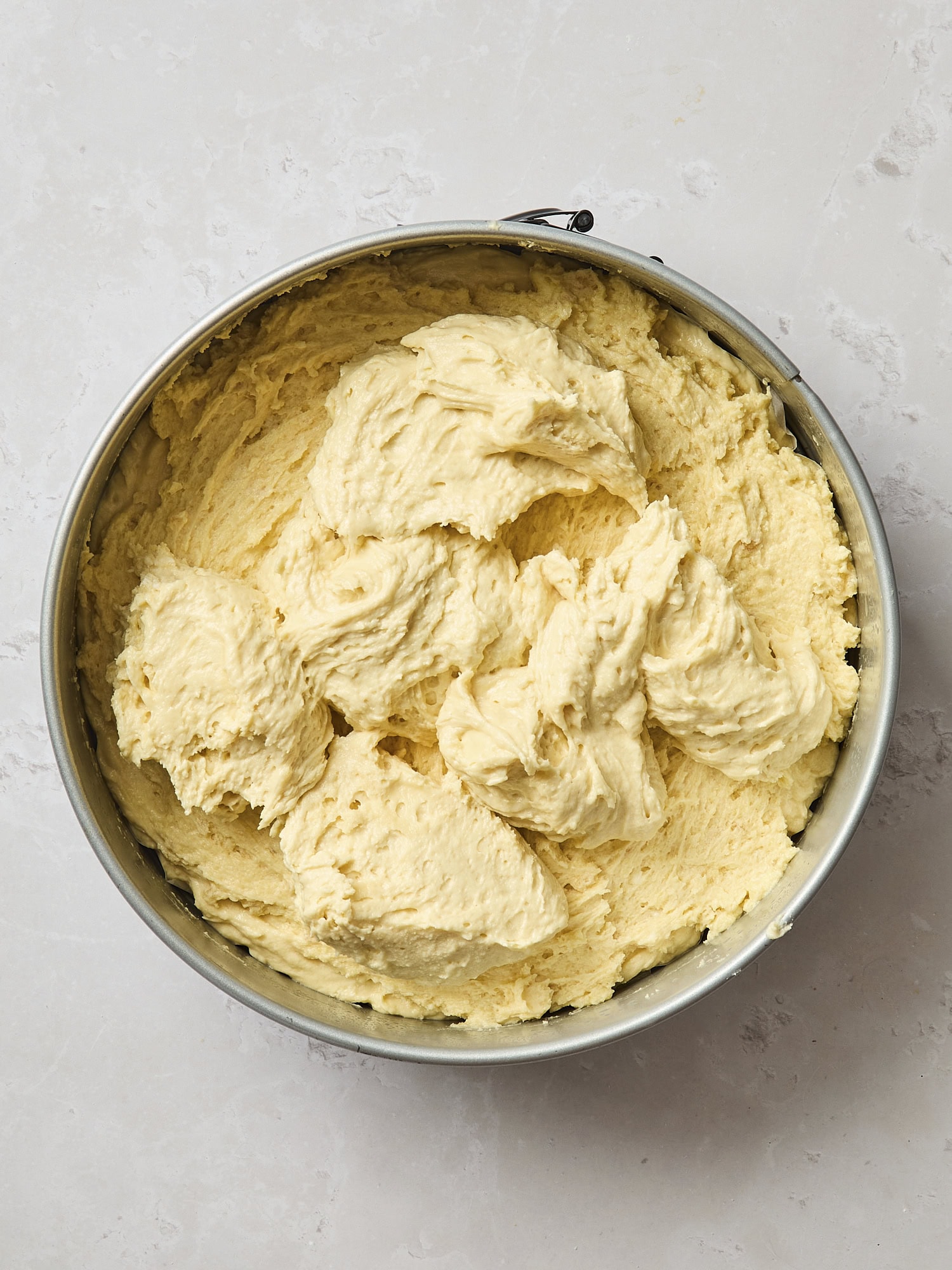 Dollops of batter on top of more batter to create a layered coffee cake.