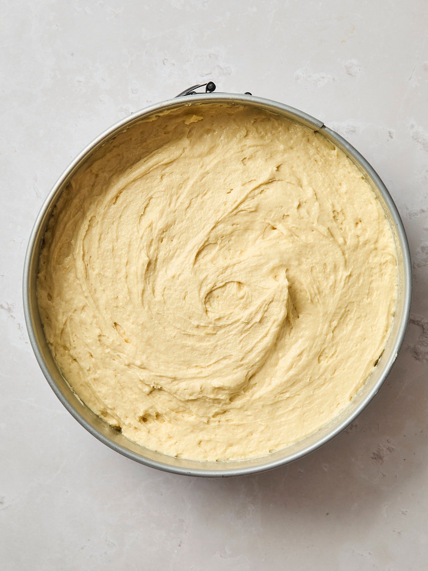 Smoothed out batter in a springform pan for a frangipane coffee cake.