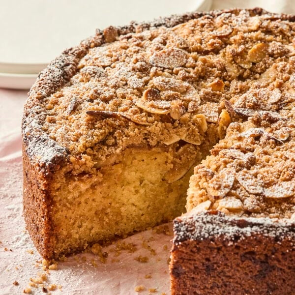 Frangipane coffee cake with almond streusel topping with slice removed showing interior texture.