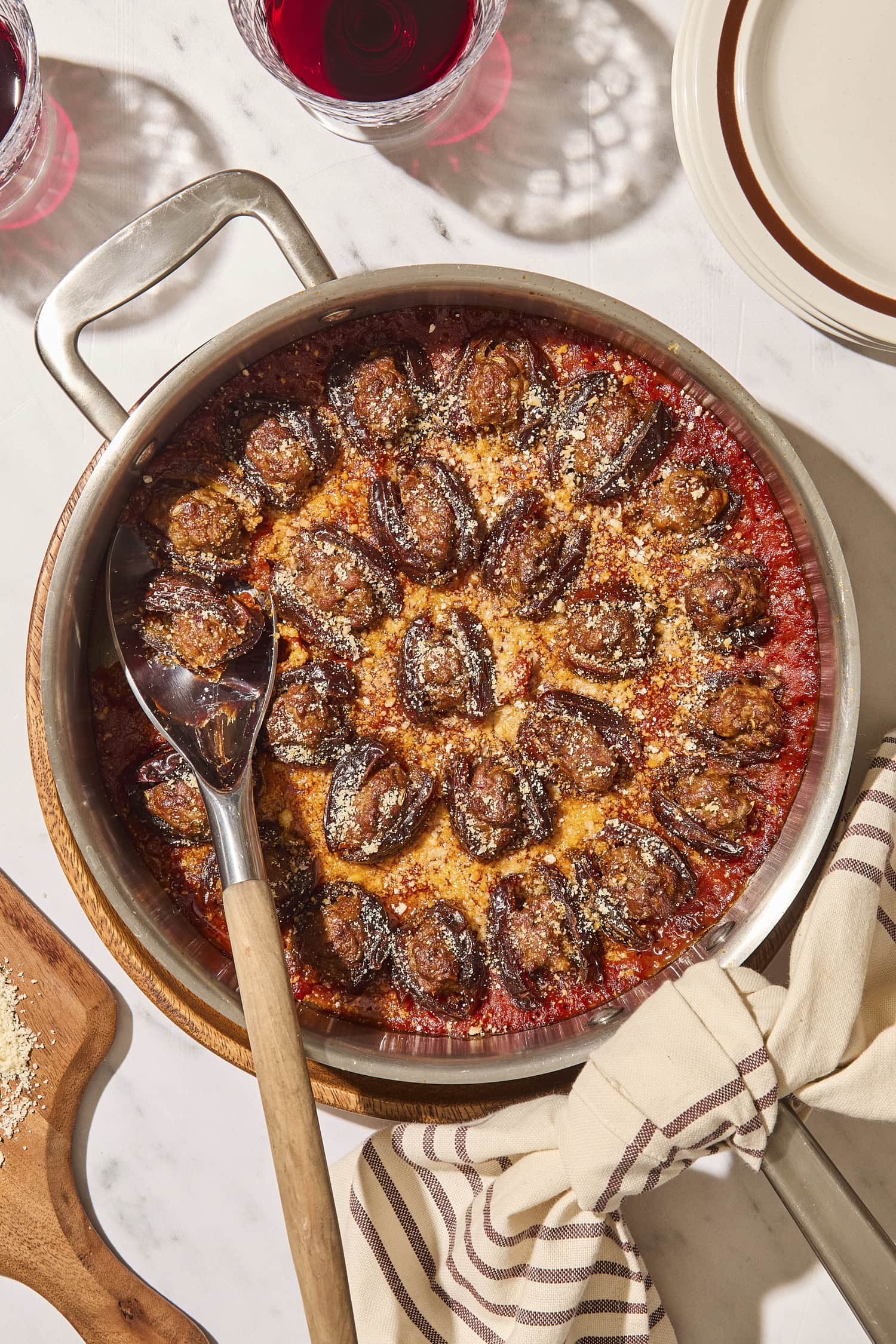 Baked stuffed dates in a round skillet with Parmesan cheese sprinkled on top.