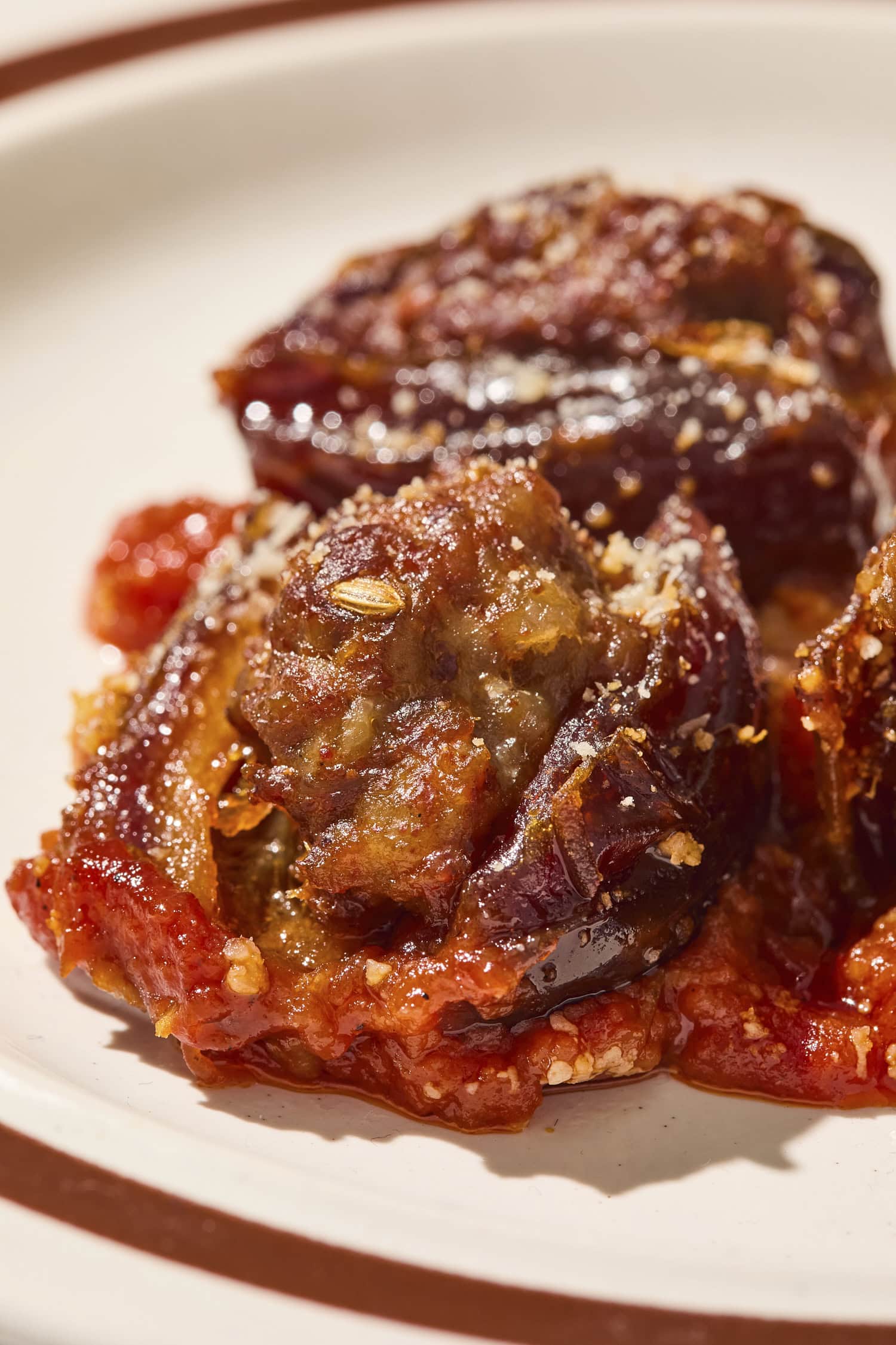 Stuffed date with bed of marinara sauce on a plate.