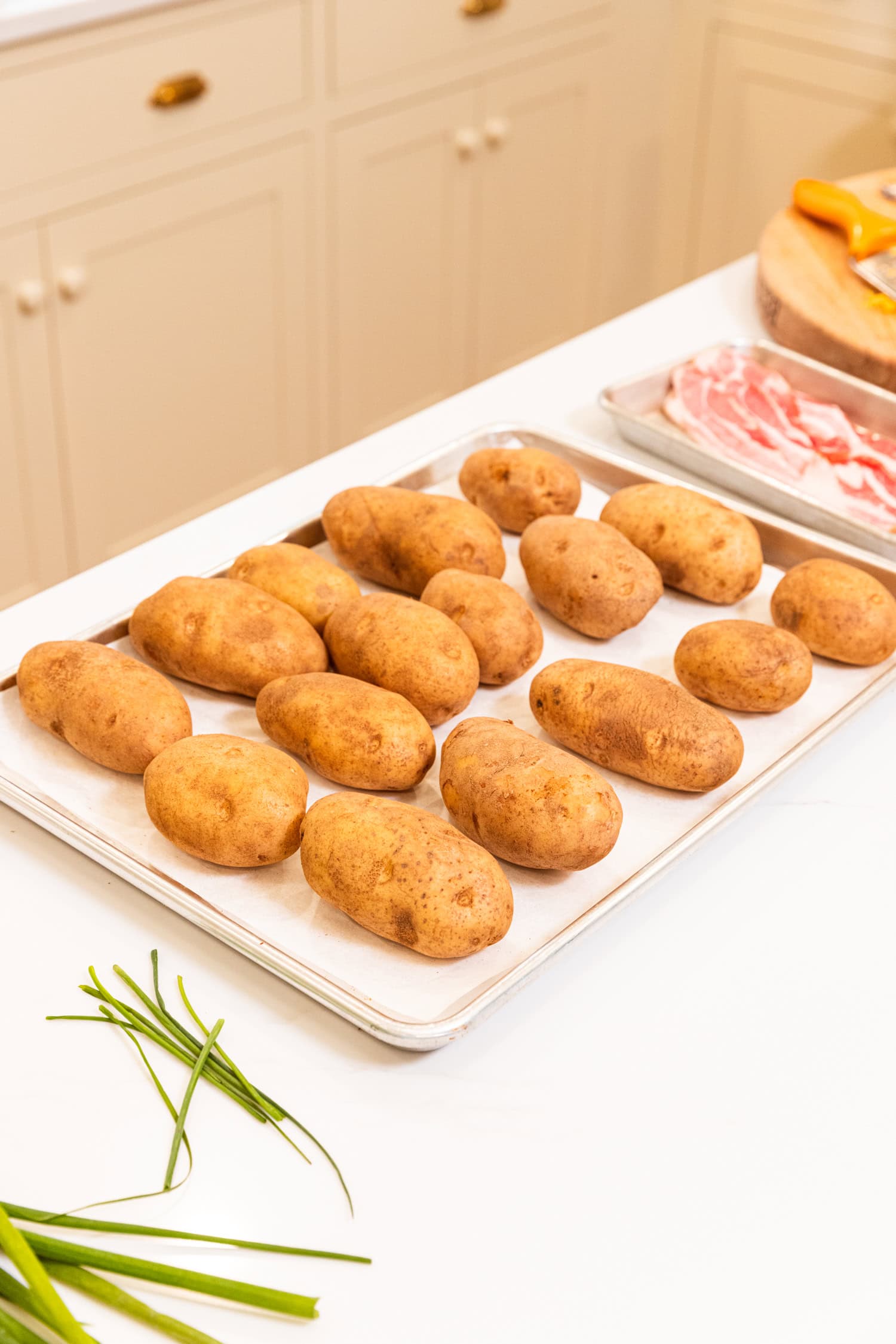 Sheet pan with potatoes ready to be baked.