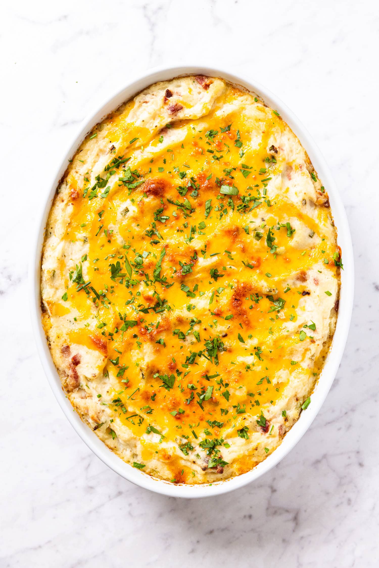 Baked potato casserole with baked cheese on top as well as parsley.