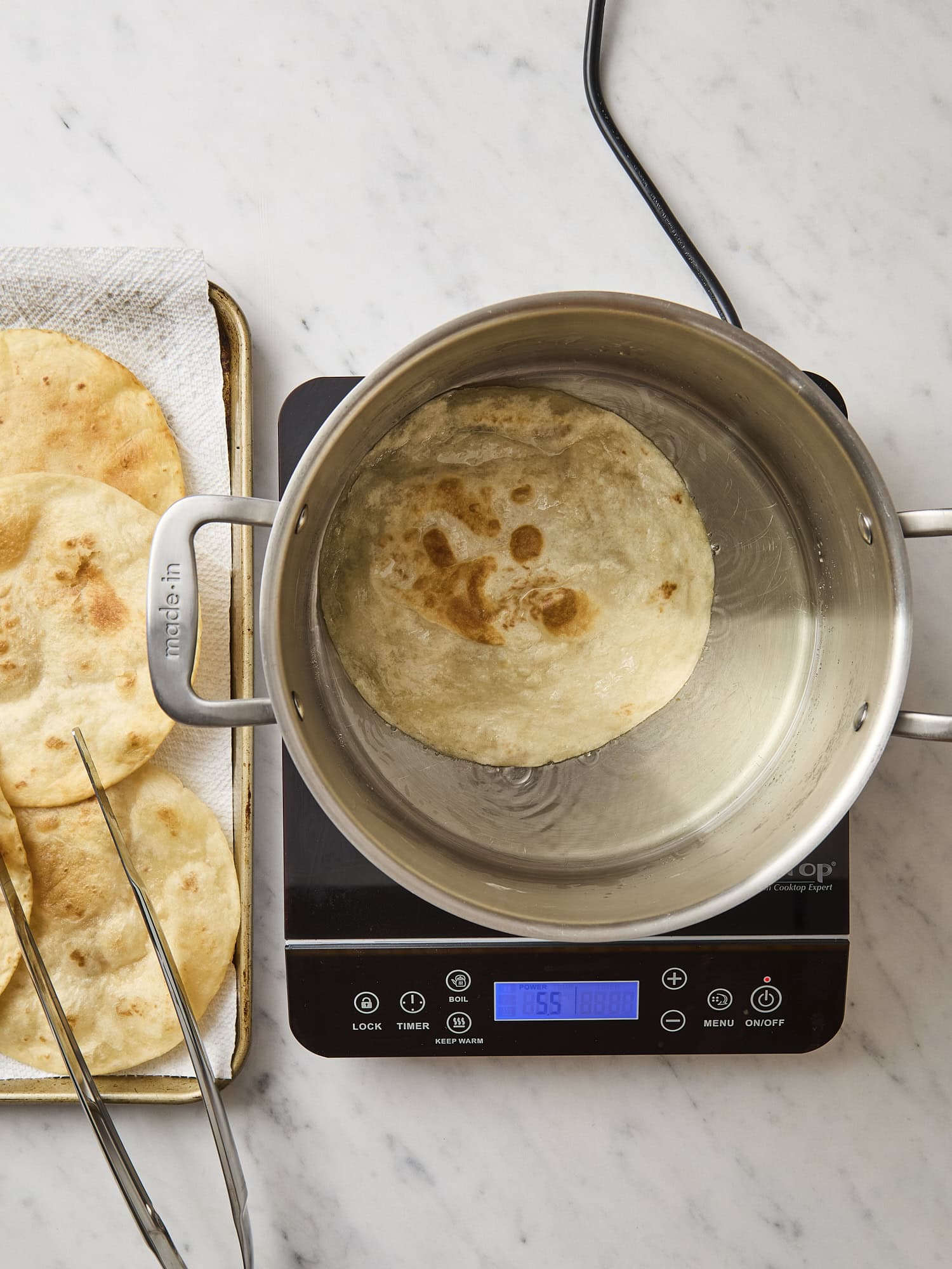 Fried flour tortillas in a stockpot.