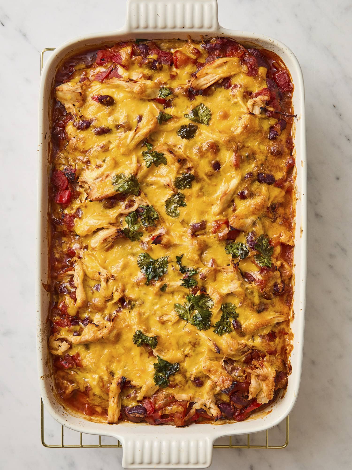 Chicken tortilla casserole in baking dish after coming out of the oven with melted cheese on top.