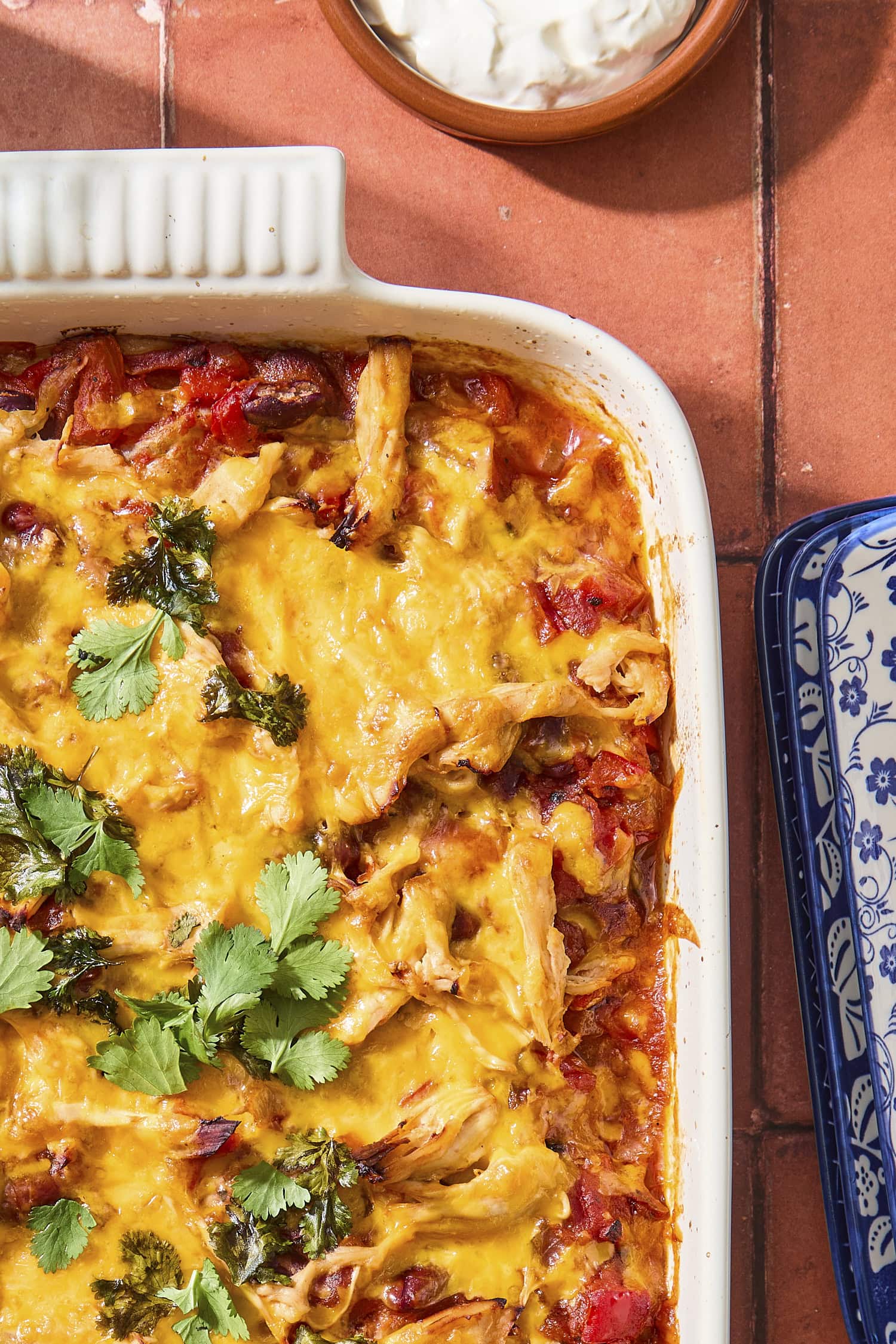 Baking pan with casserole with cheese and chopped cilantro on top.